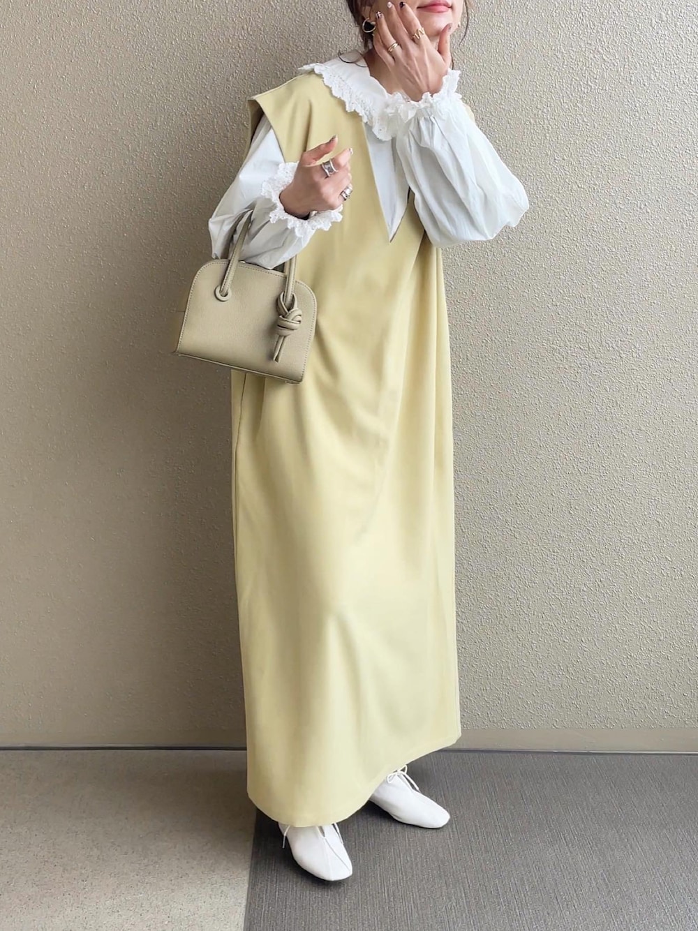 イエロー系のワンピース、ホワイト系のシャツ/ブラウス、ベージュ系のバッグを着用したレディースの冬コーディネートの1枚目の写真