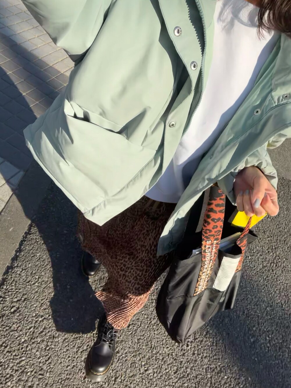 ホワイト系のスウェット、ベージュ系のスカート、ブラック系のブーツを着用したレディースの冬コーディネートの1枚目の写真