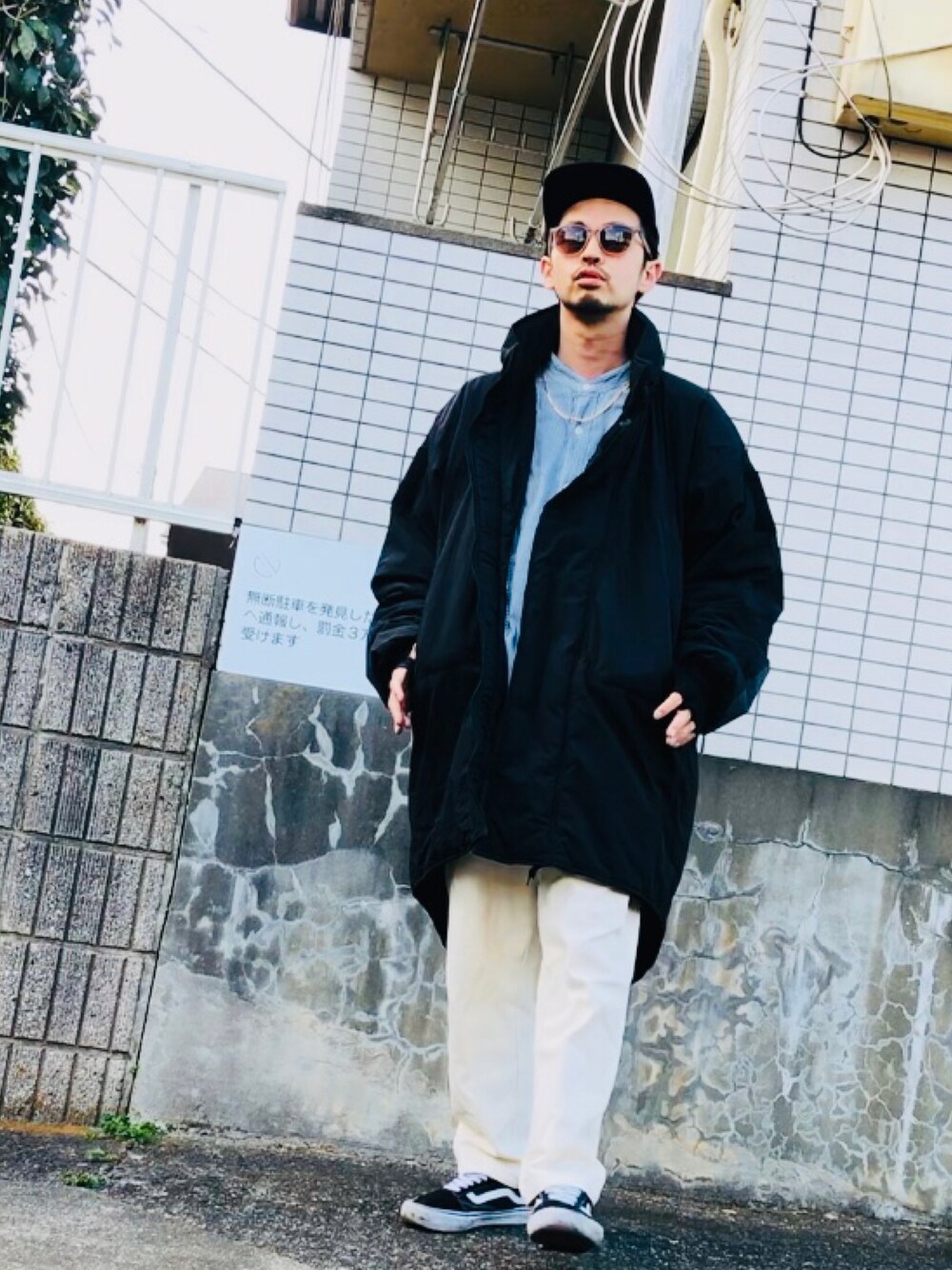 ブラック系のミリタリージャケット、ホワイト系のその他パンツ、ブラック系のスニーカーを着用したメンズの春コーディネートの1枚目の写真