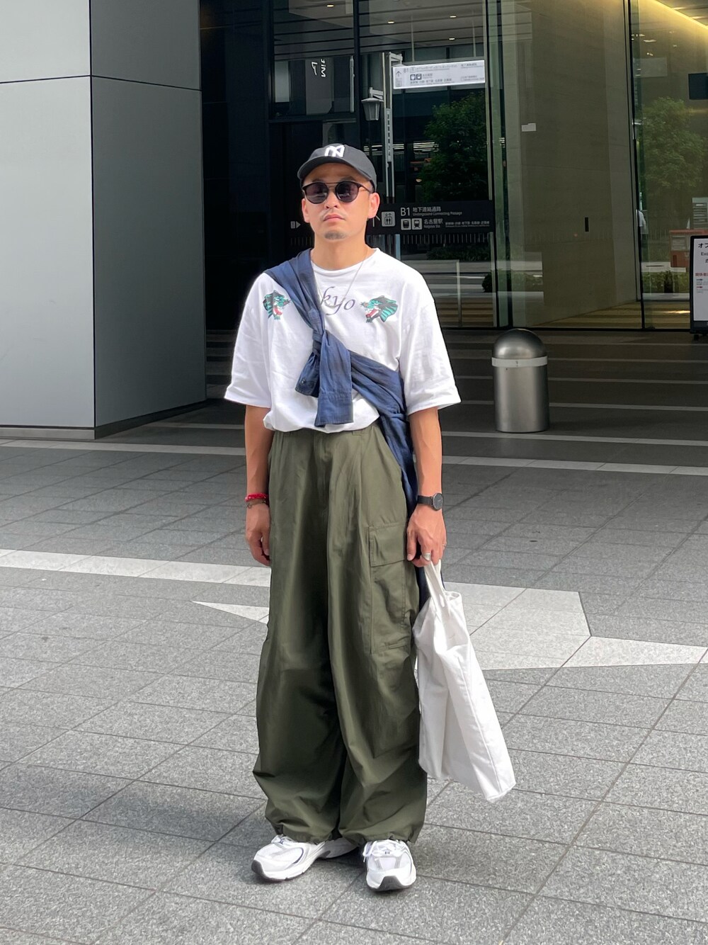 ホワイト系のTシャツ/カットソー、グリーン系のカーゴパンツ、ホワイト系のスニーカーを着用したメンズの秋コーディネートの1枚目の写真