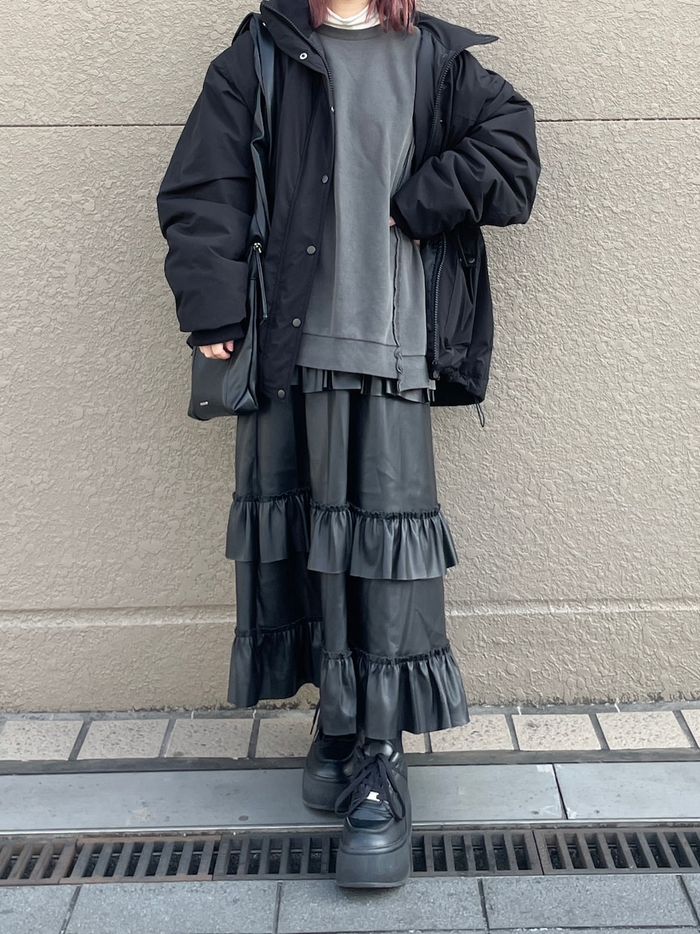 ブラック系のスニーカー、ブラック系のスカート、グレー系のスウェットを着用したレディースの冬コーディネートの1枚目の写真