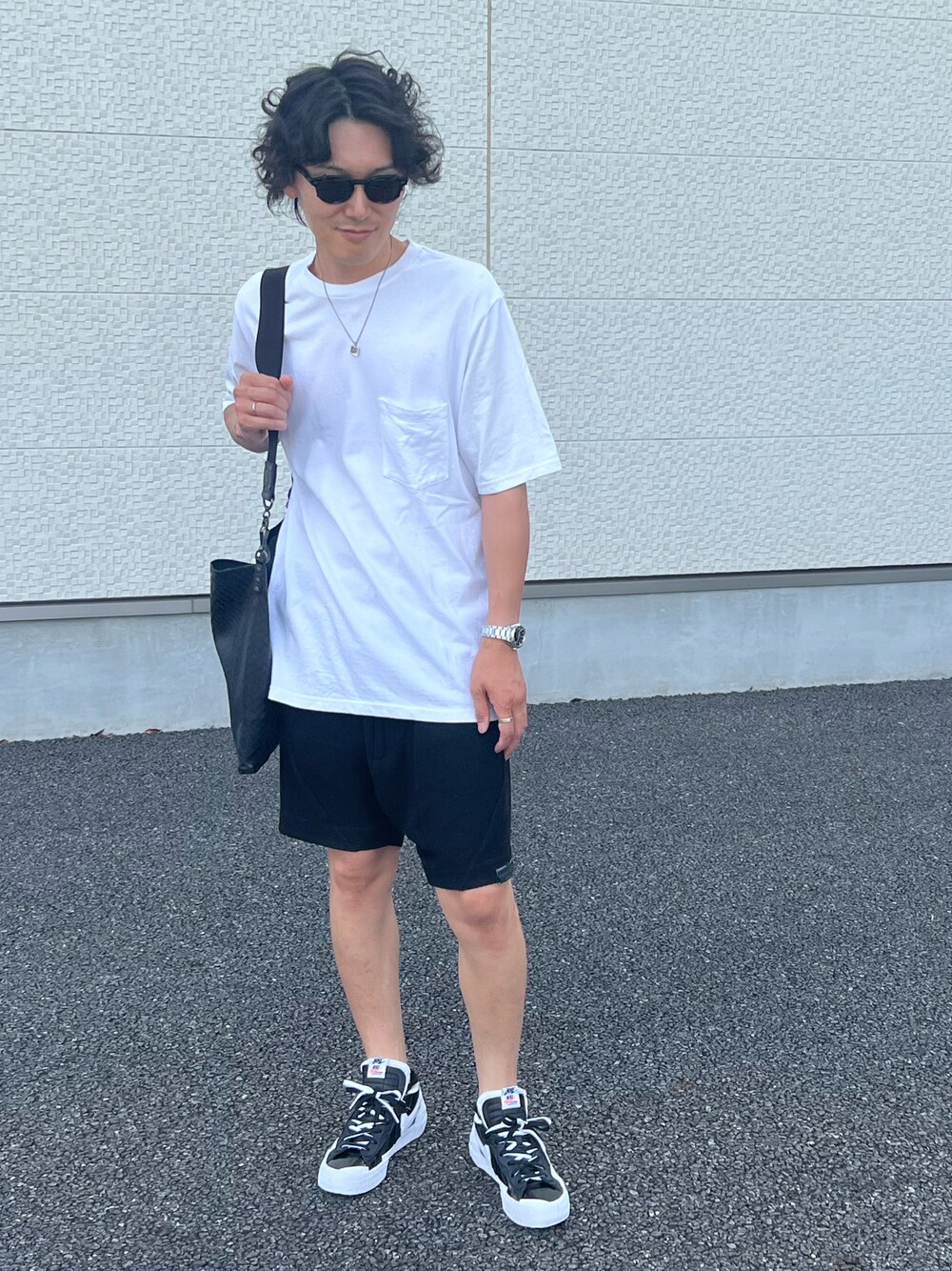 ホワイト系のTシャツ/カットソー、ブラック系のショルダーバッグ、ブラック系のパンツを着用したメンズの夏コーディネートの1枚目の写真