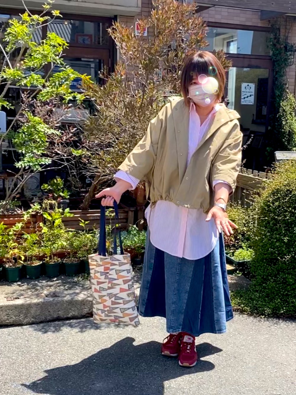 オレンジ系のシャツ/ブラウス、ブルー系のデニムスカート、ベージュ系のブルゾンを着用したレディースの春コーディネートの1枚目の写真