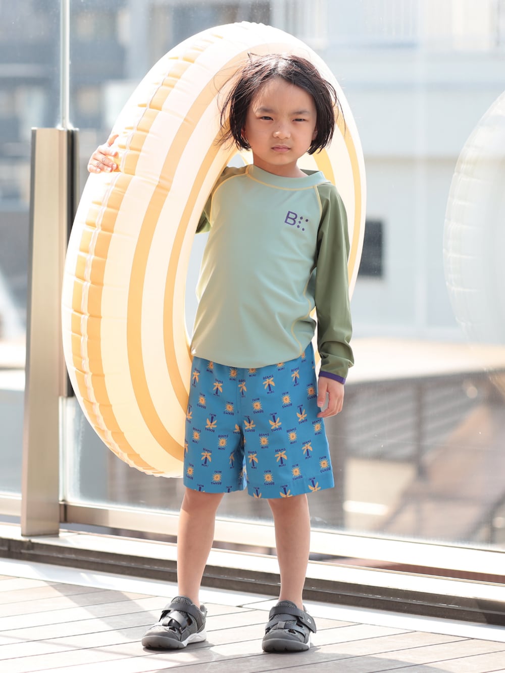 グリーン系の水着を着用したキッズの夏コーディネートの1枚目の写真