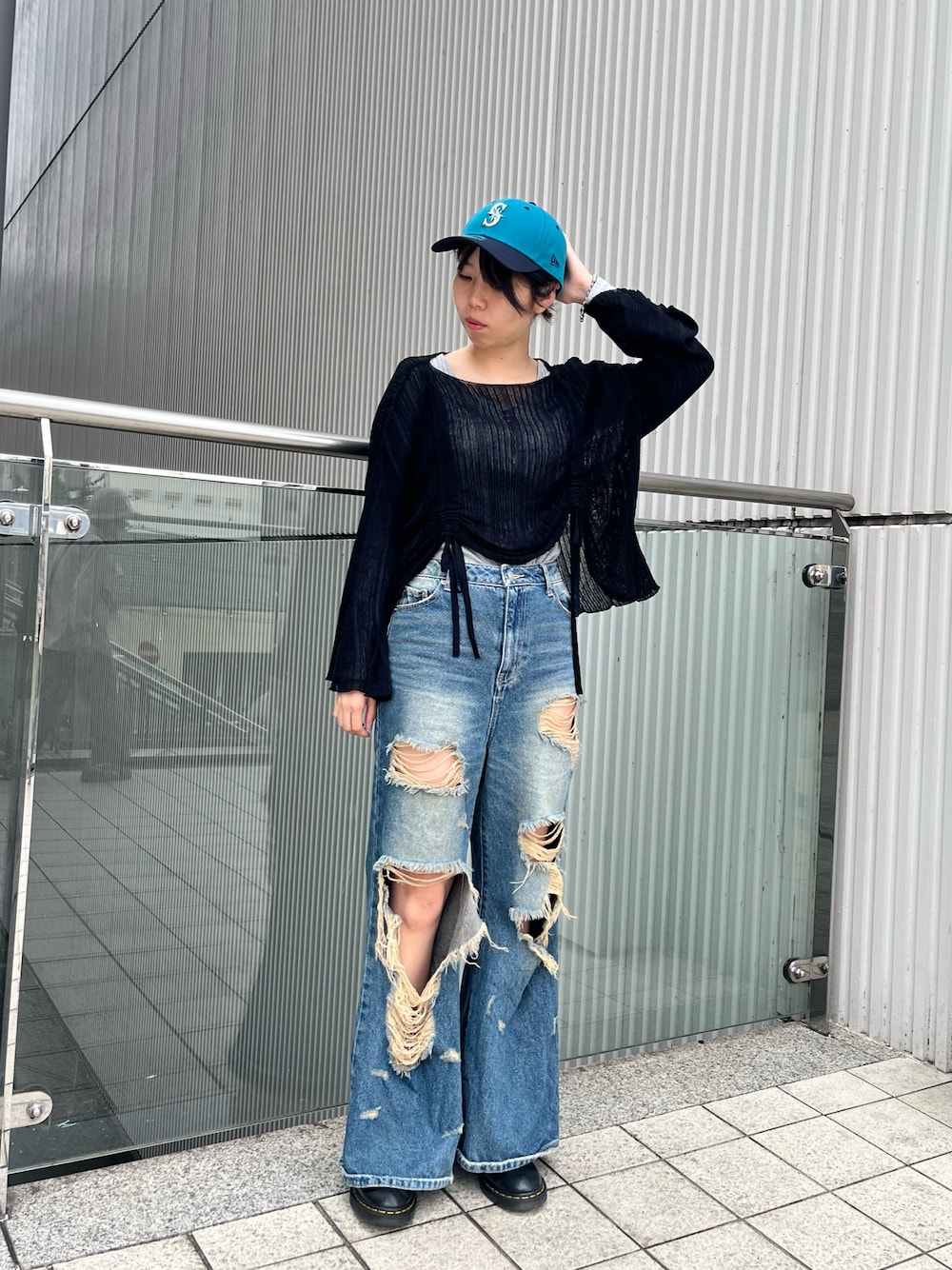 ブルー系のデニムパンツ、ブルー系のキャップを着用したレディースの秋コーディネートの1枚目の写真