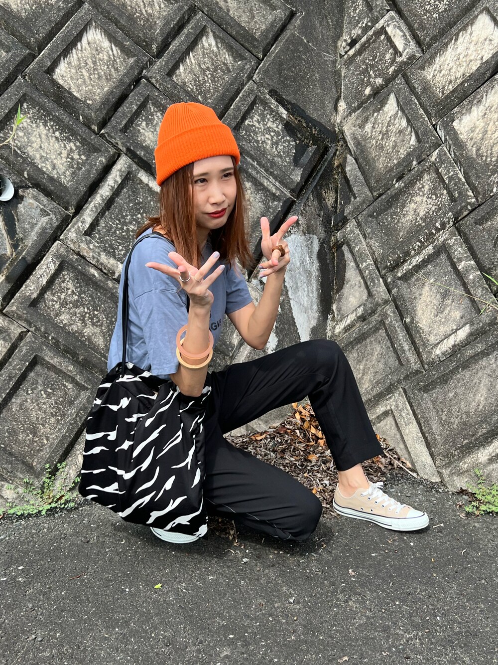ブルー系のTシャツ/カットソー、ブラック系のパンツ、ベージュ系のスニーカーを着用したレディースの秋コーディネートの1枚目の写真