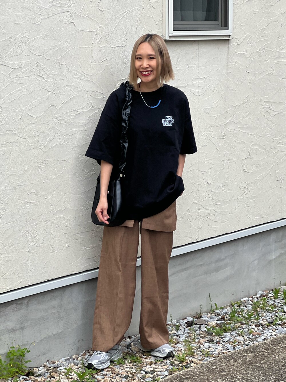 ブラック系のTシャツ/カットソー、ベージュ系のその他パンツ、シルバー系のスニーカーを着用したレディースの春コーディネートの1枚目の写真