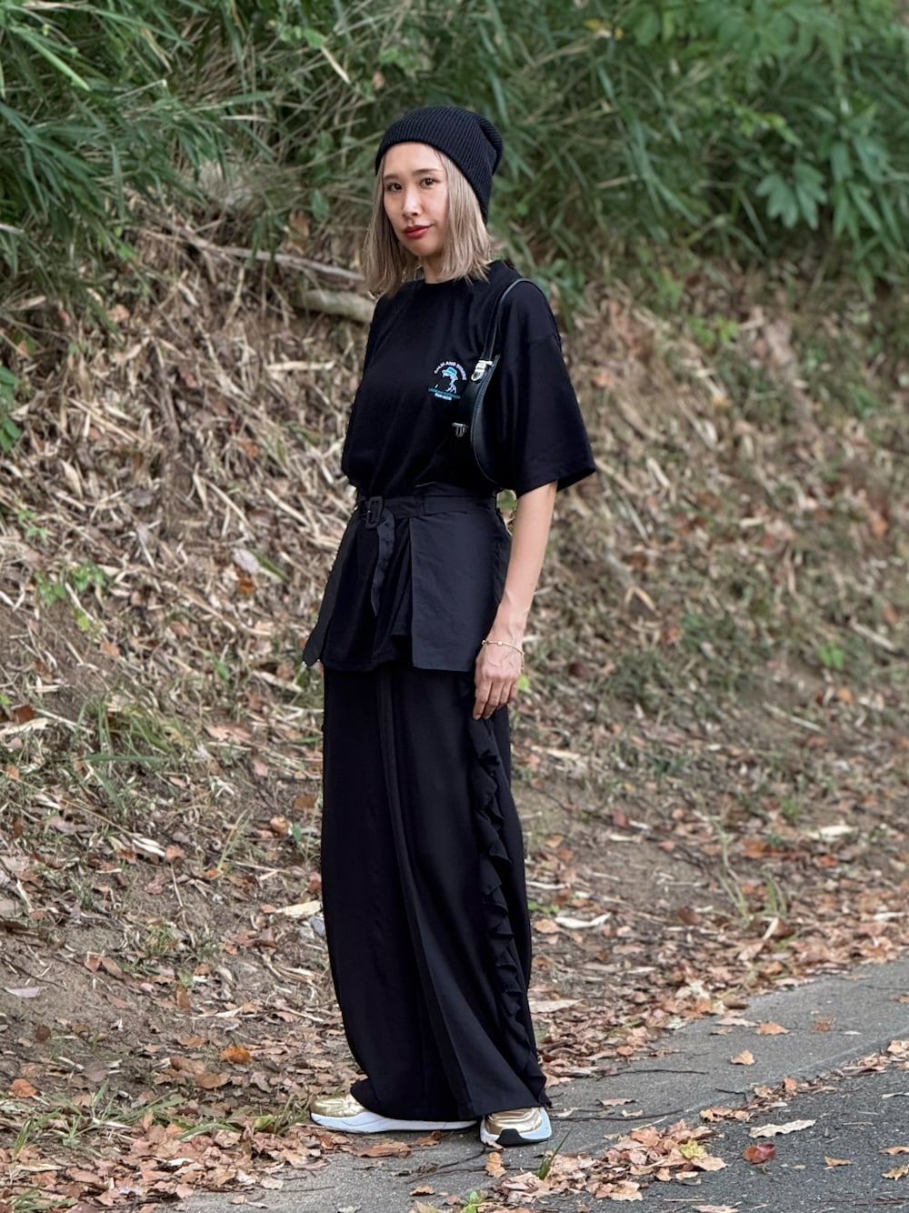 ブラック系のTシャツ/カットソー、ブラック系のその他パンツ、ゴールド系のスニーカーを着用したレディースの夏コーディネートの1枚目の写真