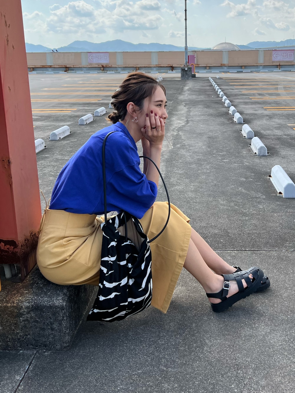 ブルー系のTシャツ/カットソー、イエロー系のスカート、ブラック系のサンダルを着用したレディースの夏コーディネートの1枚目の写真