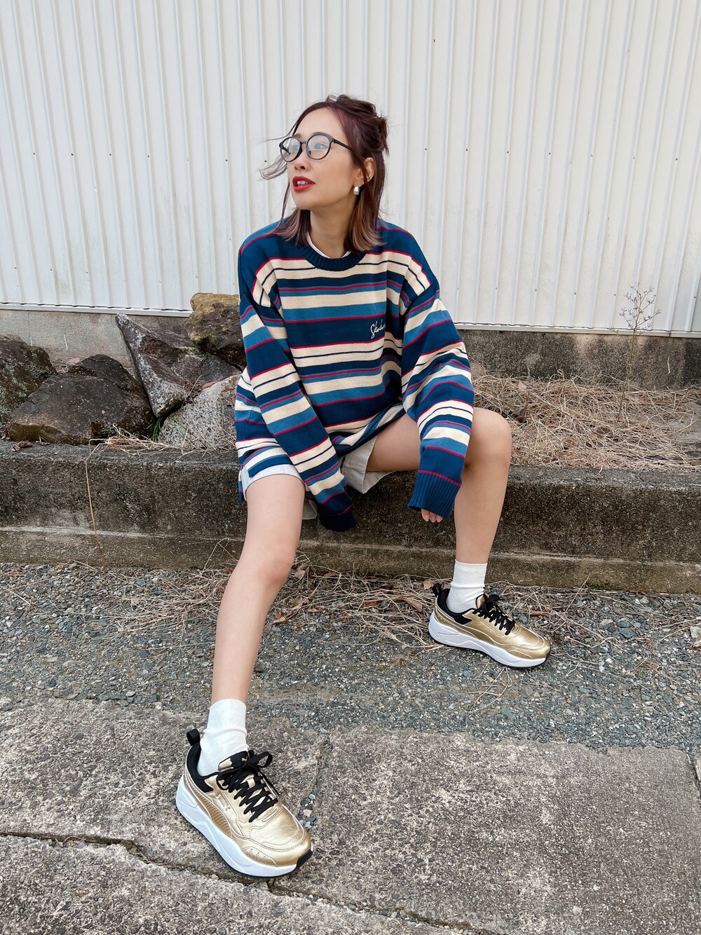 ブルー系のニット/セーター、ゴールド系のスニーカー、シルバー系のリングを着用したレディースの冬コーディネートの1枚目の写真