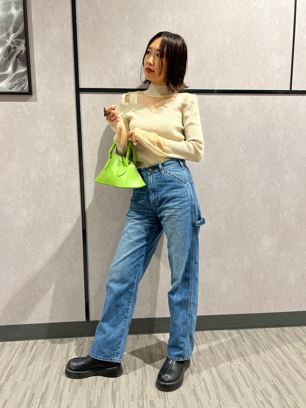 ブルー系のデニムパンツ、ホワイト系のタンクトップ、ベージュ系のニット/セーターを着用したレディースの秋コーディネートの1枚目の写真