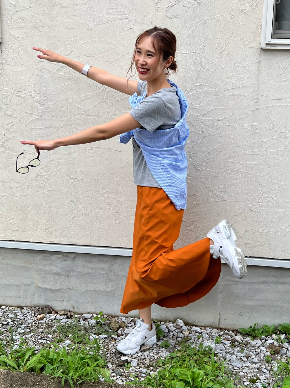 イエロー系のスカート、ブルー系のシャツ/ブラウス、グレー系のスニーカーを着用したレディースの夏コーディネートの1枚目の写真