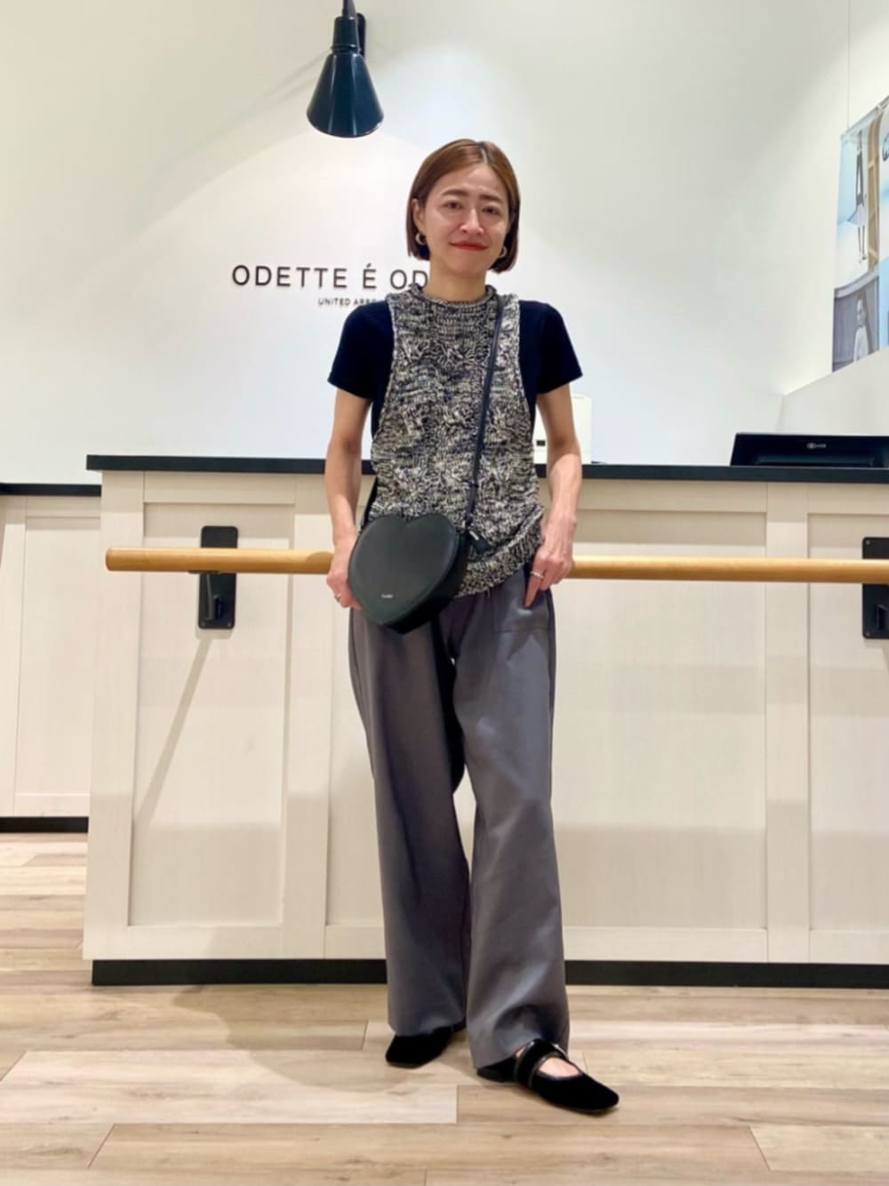 ブラック系のショルダーバッグ、ブラック系のパンプスを着用したレディースの秋コーディネートの1枚目の写真