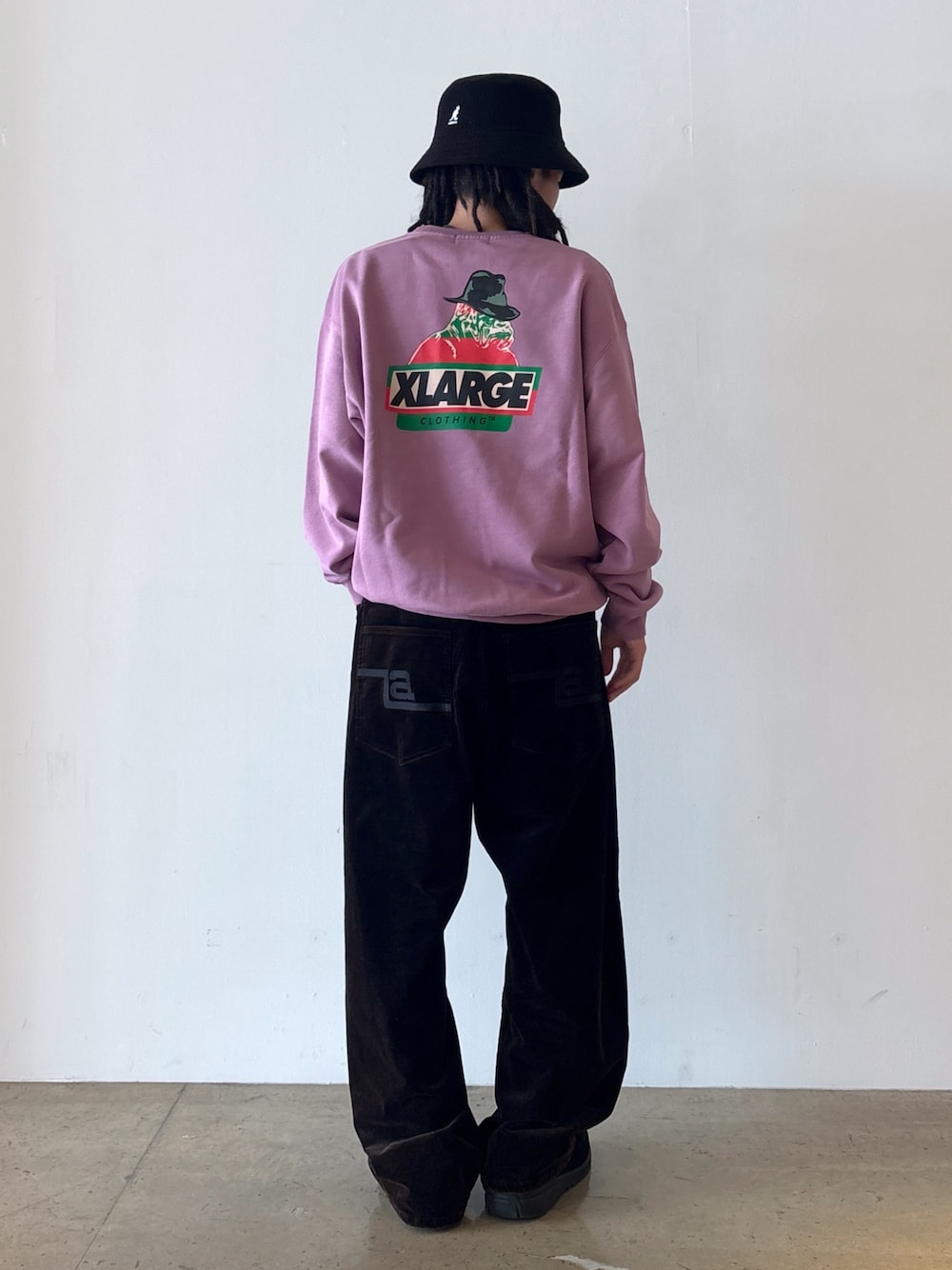 パープル系のスウェット、ブラック系のその他パンツ、ブラック系のハットを着用したメンズの秋コーディネートの1枚目の写真