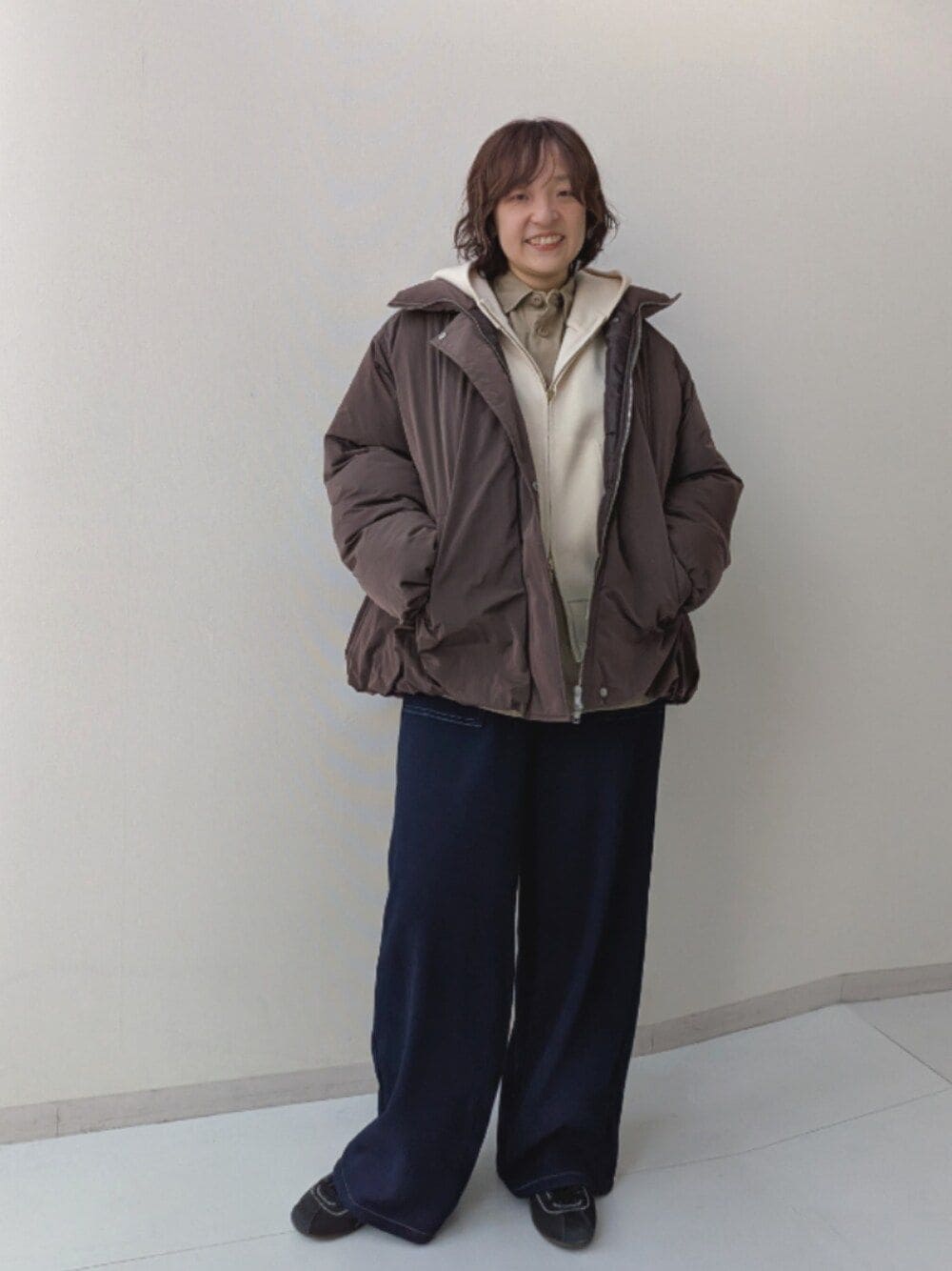 ベージュ系のシャツ/ブラウス、ブラウン系のカバーオール、ブルー系のデニムパンツを着用したレディースの秋コーディネートの1枚目の写真