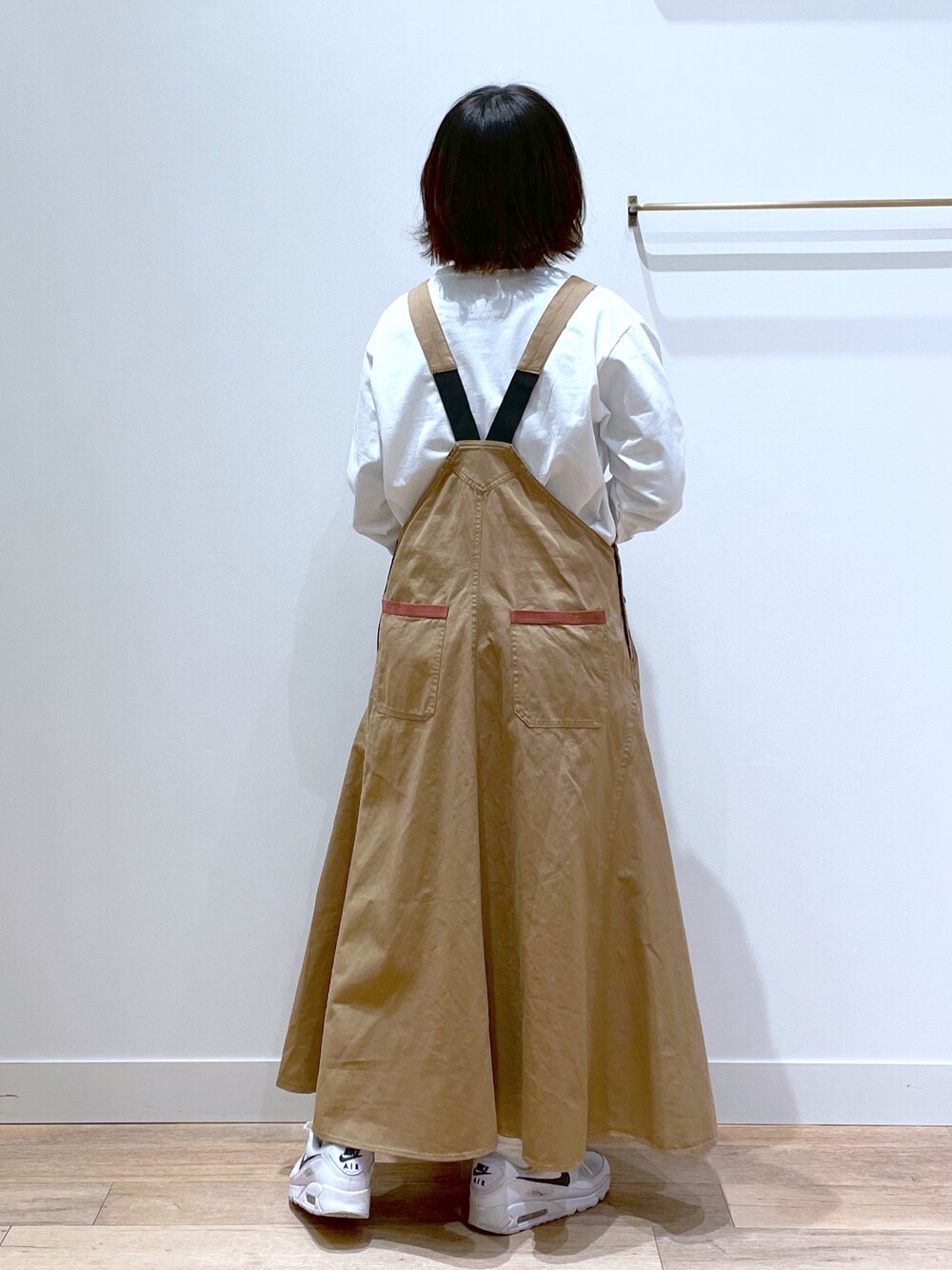 ベージュ系のジャンパースカート、ホワイト系のTシャツ/カットソー、その他のエコバッグ/サブバッグを着用したレディースの春コーディネートの2枚目の写真