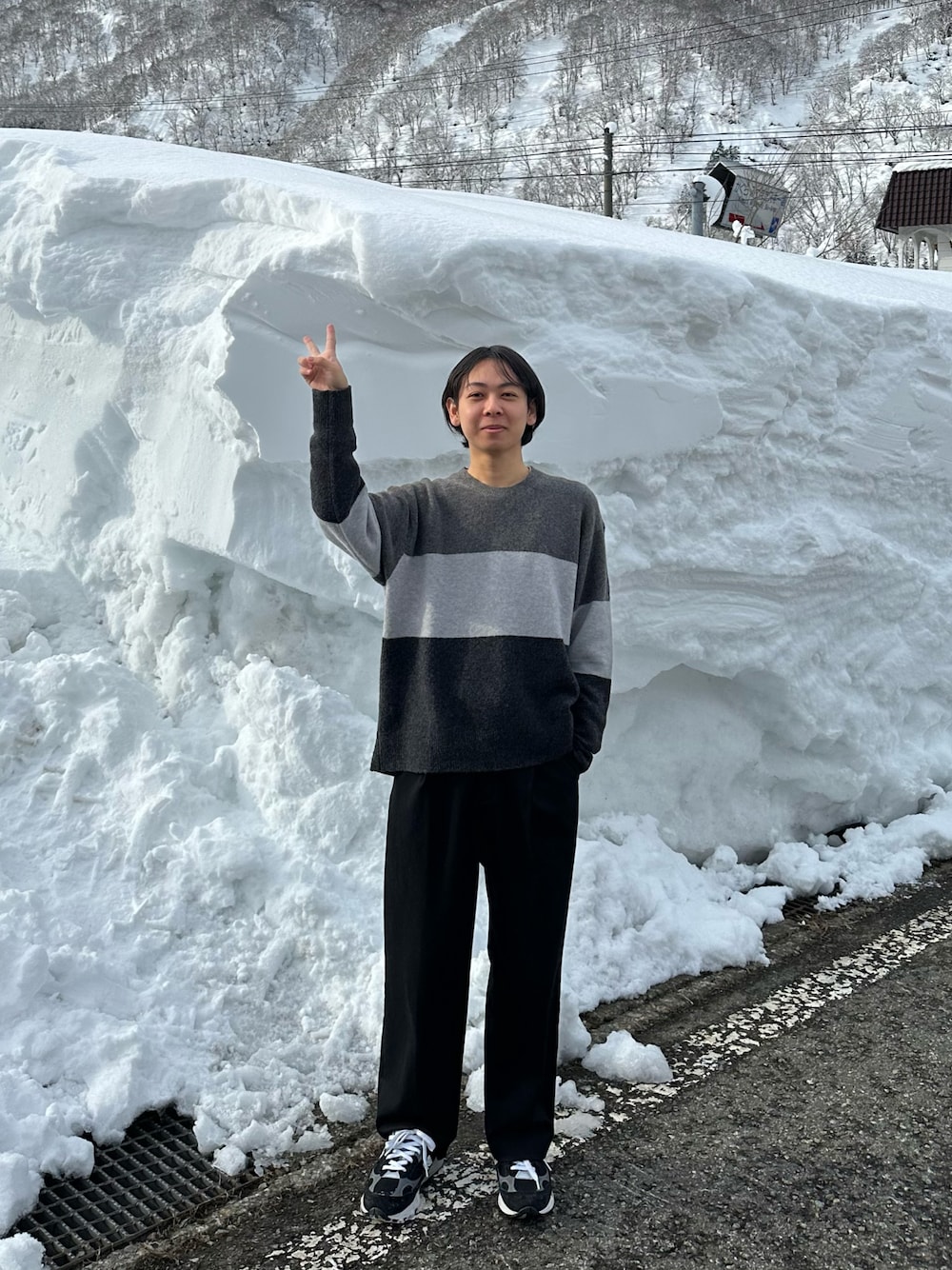 ブラック系のニット/セーター、ブラック系のスラックス、ブラック系のスニーカーを着用したメンズの冬コーディネートの1枚目の写真