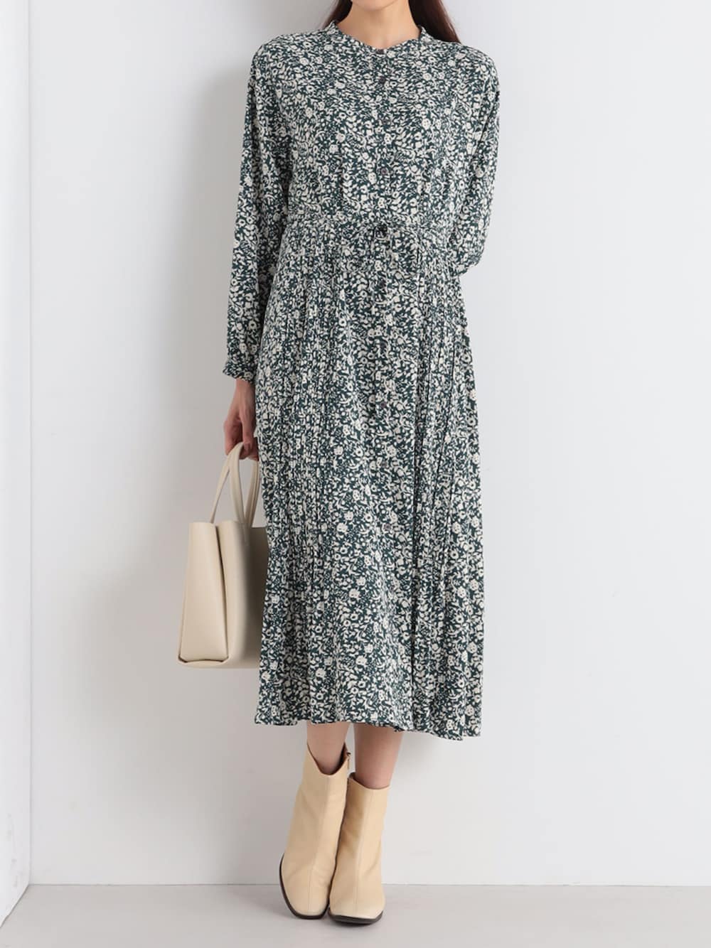 グリーン系のワンピースを着用したレディースの冬コーディネートの1枚目の写真