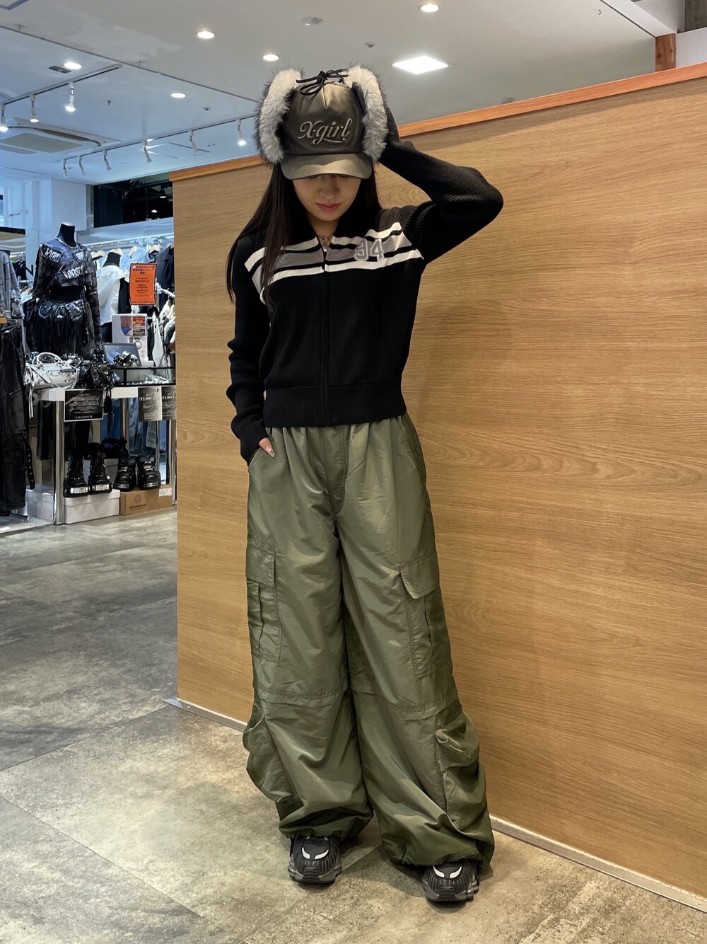 ブラック系のニット/セーター、グリーン系のカーゴパンツ、ブラック系のキャップを着用したレディースの秋コーディネートの1枚目の写真