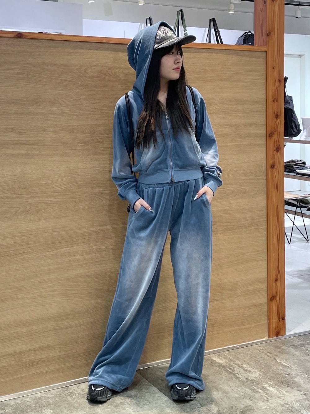 ブルー系のパーカー、ブラック系のタンクトップ、ブラック系のバックパック/リュックを着用したレディースの秋コーディネートの1枚目の写真