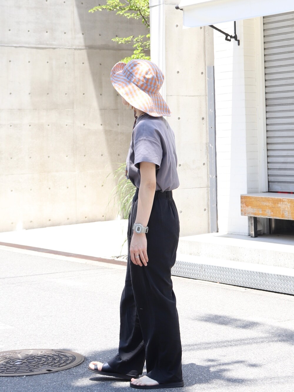 グレー系のTシャツ/カットソー、オレンジ系のハットを着用したレディースの夏コーディネートの2枚目の写真