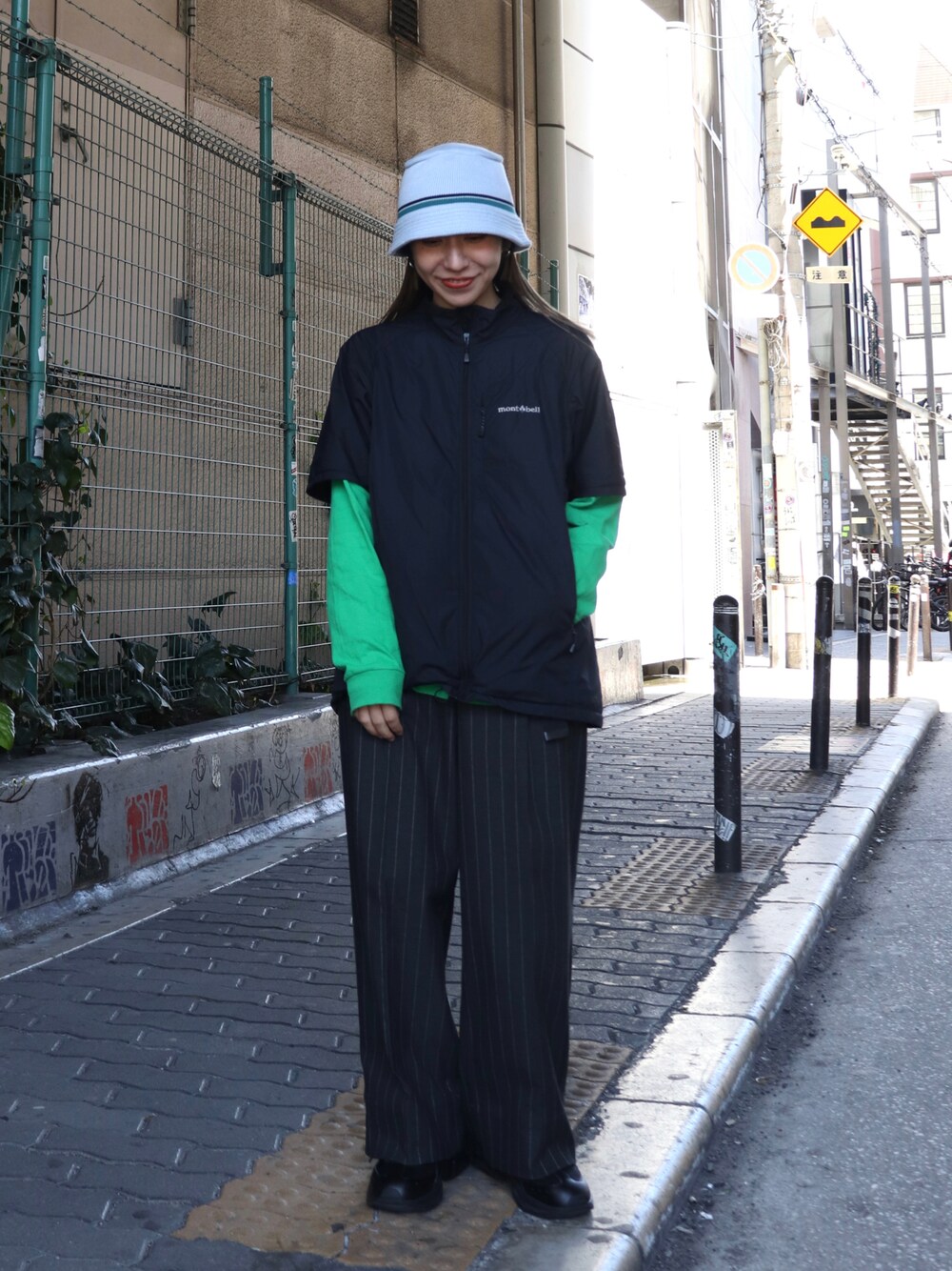 ブラック系のトップス、ブルー系のハットを着用したレディースの夏コーディネートの1枚目の写真
