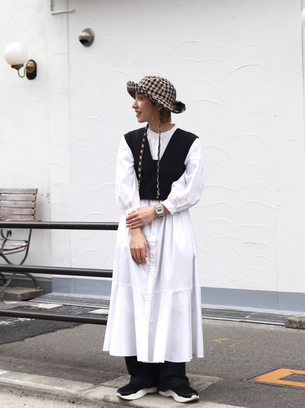 ホワイト系のワンピース、ブルー系のパンツ、ブラック系のハットを着用したレディースの春コーディネートの2枚目の写真