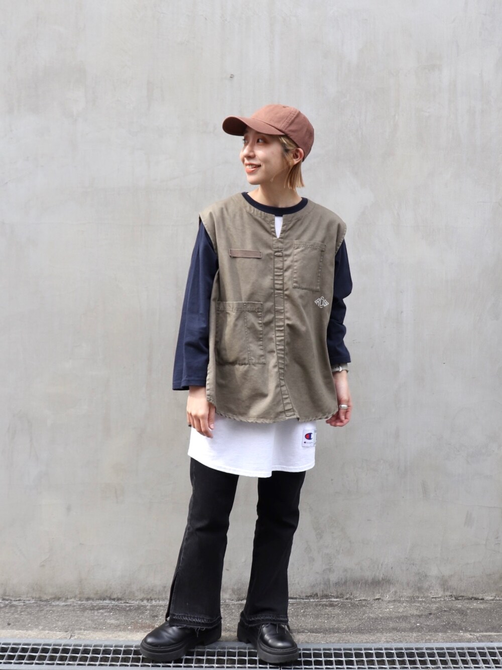 グリーン系のベスト、ホワイト系のTシャツ/カットソー、ブラック系のデニムパンツを着用したレディースの春コーディネートの1枚目の写真
