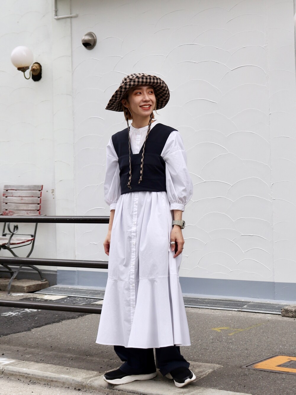 ホワイト系のワンピース、ブルー系のパンツ、ブラック系のハットを着用したレディースの春コーディネートの3枚目の写真