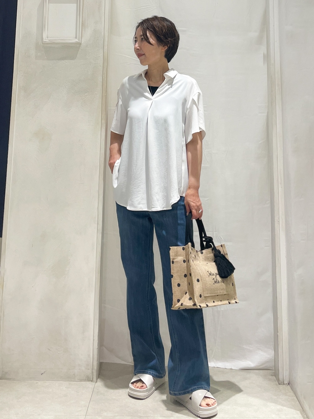 ホワイト系のシャツ/ブラウス、ブラック系のタンクトップ、ブルー系のデニムパンツを着用したレディースの夏コーディネートの1枚目の写真