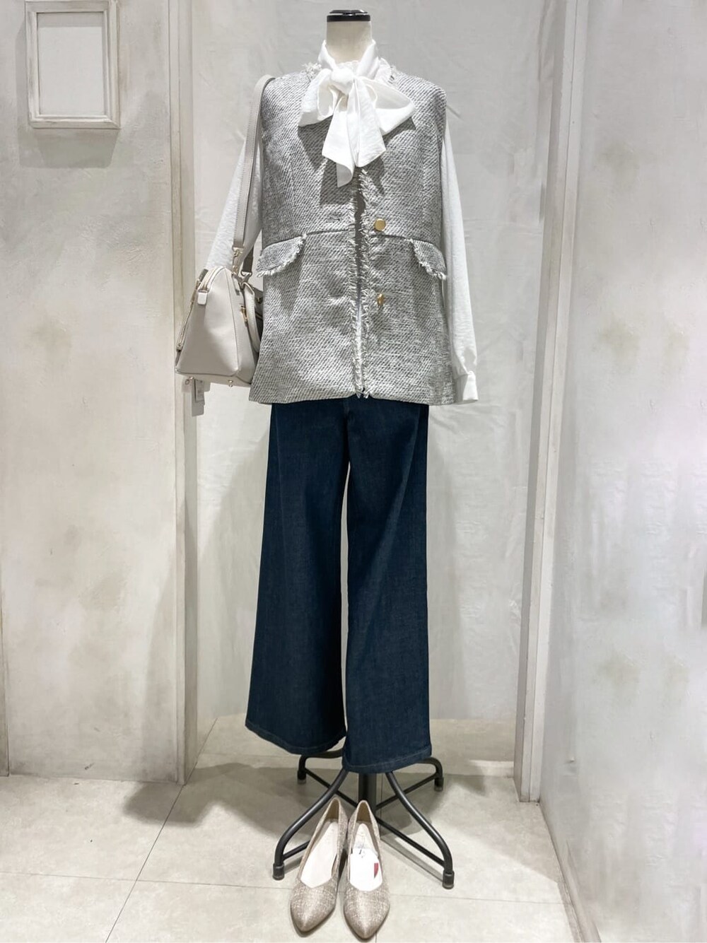 ホワイト系のシャツ/ブラウス、ブルー系のデニムパンツ、グレー系のトートバッグを着用したレディースの冬コーディネートの1枚目の写真