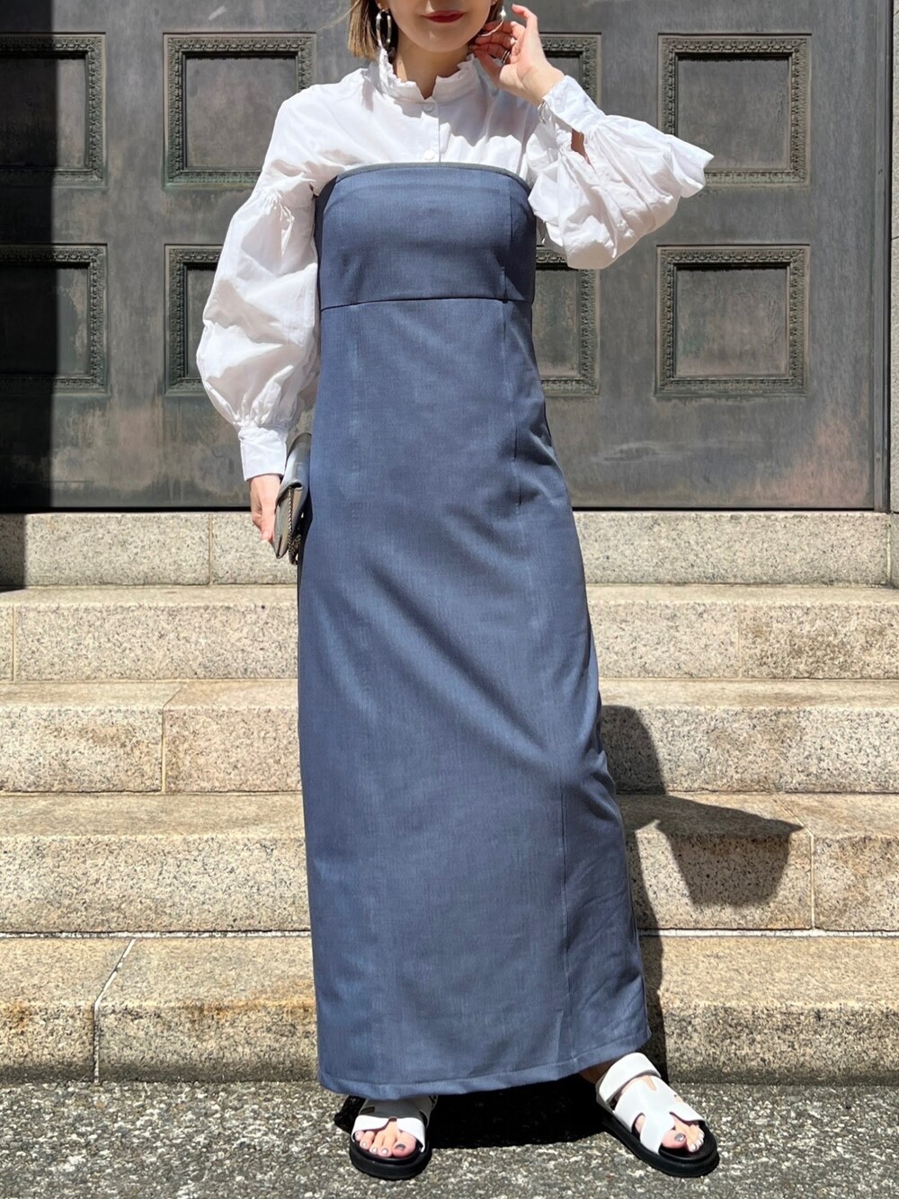 ブルー系のジャンパースカートを着用したレディースの春コーディネートの1枚目の写真