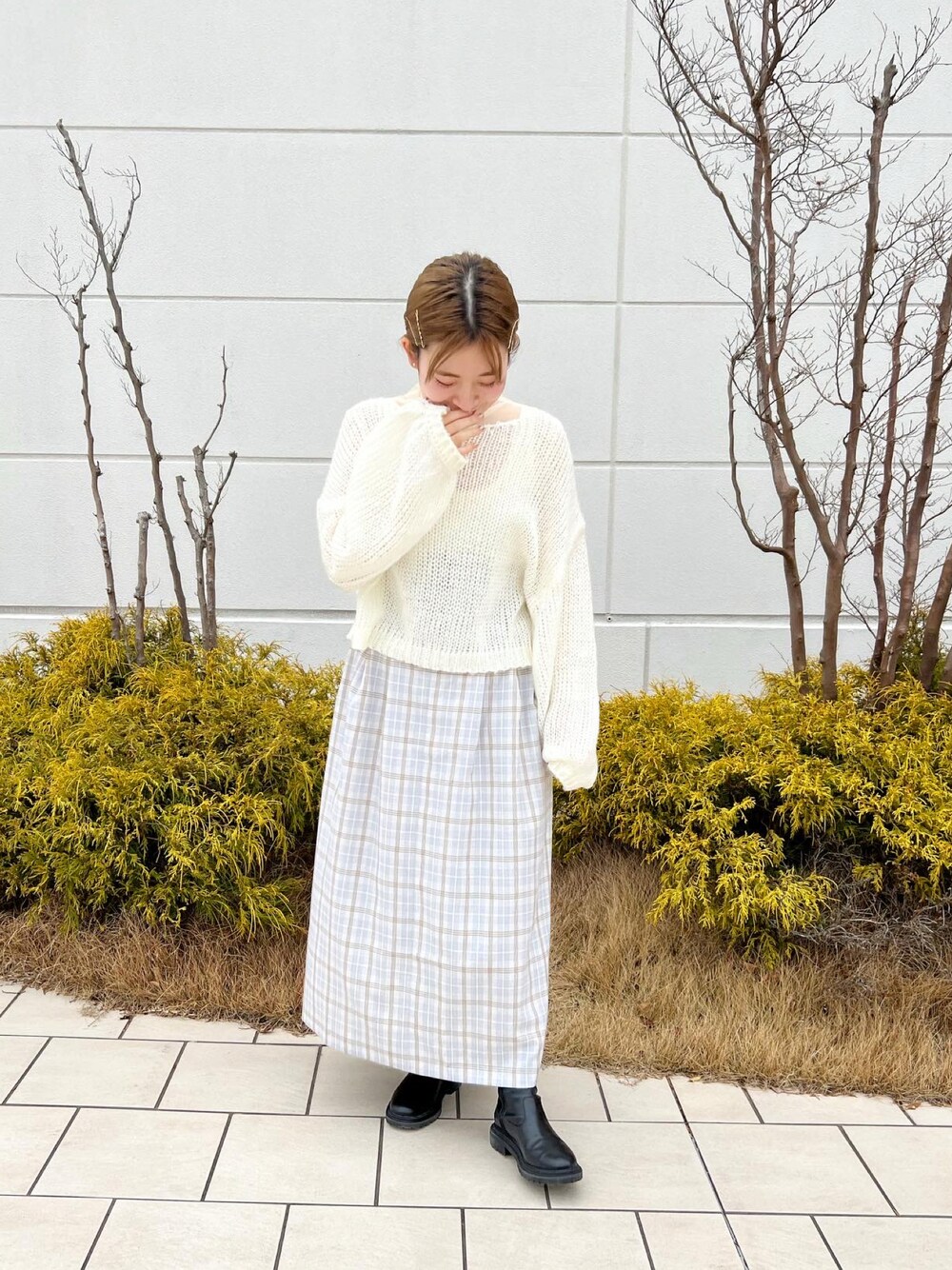 ホワイト系のニット/セーター、パープル系のスカート、ホワイト系のTシャツ/カットソーを着用したレディースの冬コーディネートの1枚目の写真