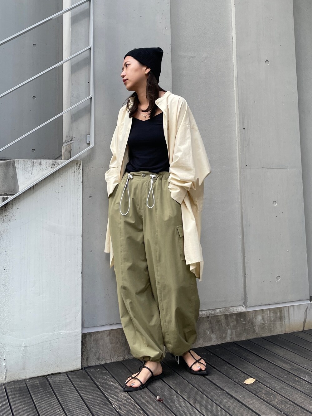 グリーン系のカーゴパンツ、イエロー系のシャツ/ブラウス、ブラック系のサンダルを着用したレディースの秋コーディネートの1枚目の写真