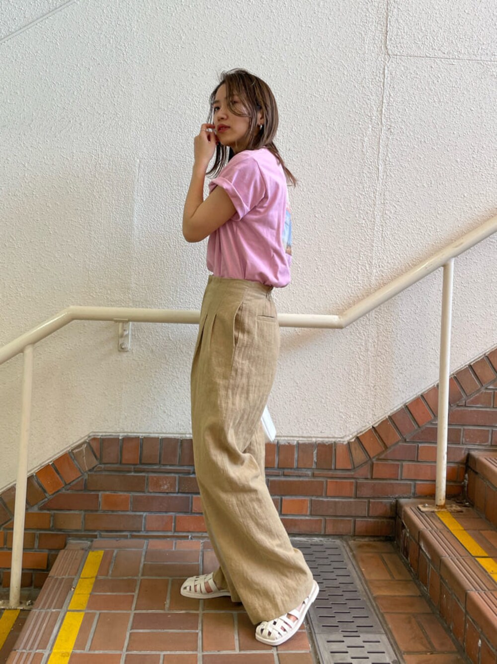 ベージュ系のその他パンツ、ピンク系のTシャツ/カットソー、ホワイト系のサンダルを着用したレディースの春コーディネートの1枚目の写真