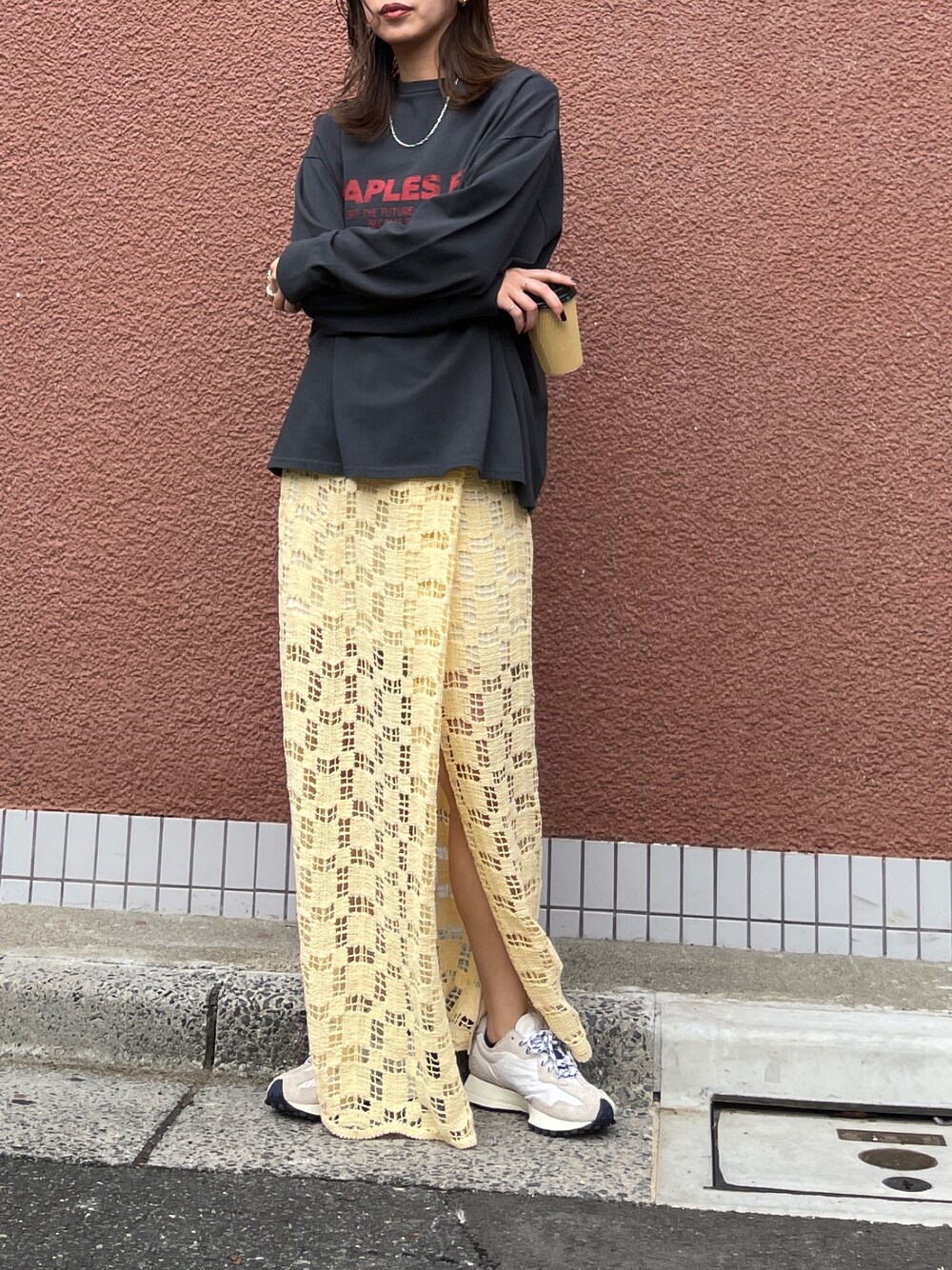 イエロー系のスカート、グレー系のTシャツ/カットソーを着用したレディースの冬コーディネートの1枚目の写真