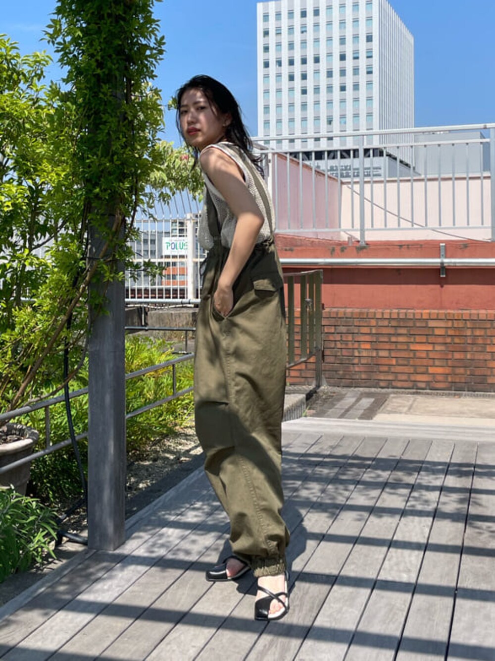 ベージュ系のサロペット/オーバーオール、ブラック系のサンダル、ブラック系のハンドバッグを着用したレディースの春コーディネートの1枚目の写真