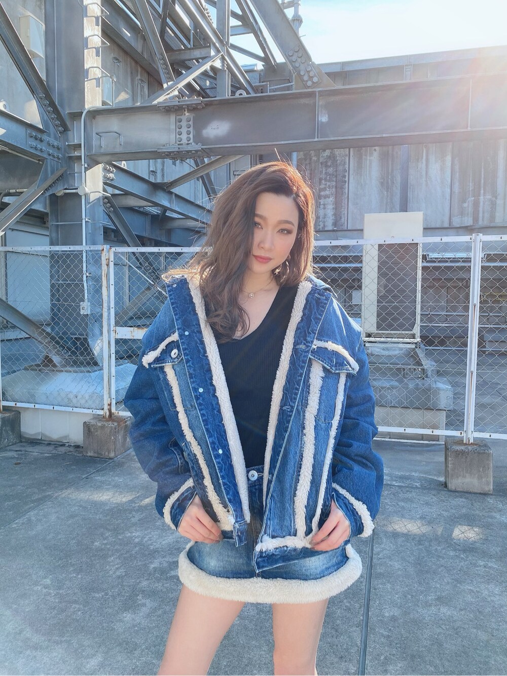 ブラック系のニット/セーター、ブルー系のデニムジャケット、ブルー系のデニムスカートを着用したレディースの冬コーディネートの1枚目の写真