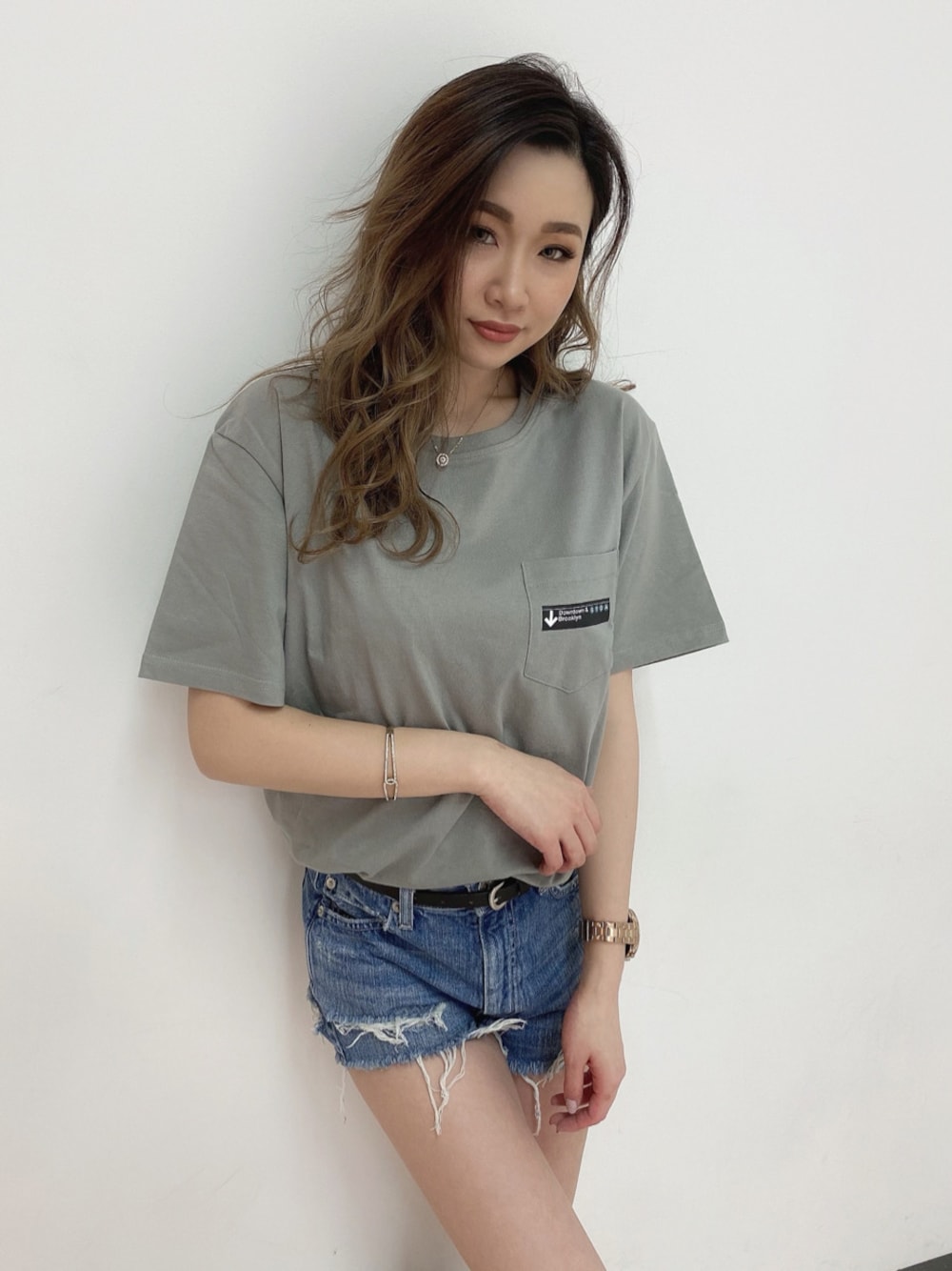 ブルー系のデニムパンツ、グリーン系のTシャツ/カットソーを着用したレディースの春コーディネートの1枚目の写真