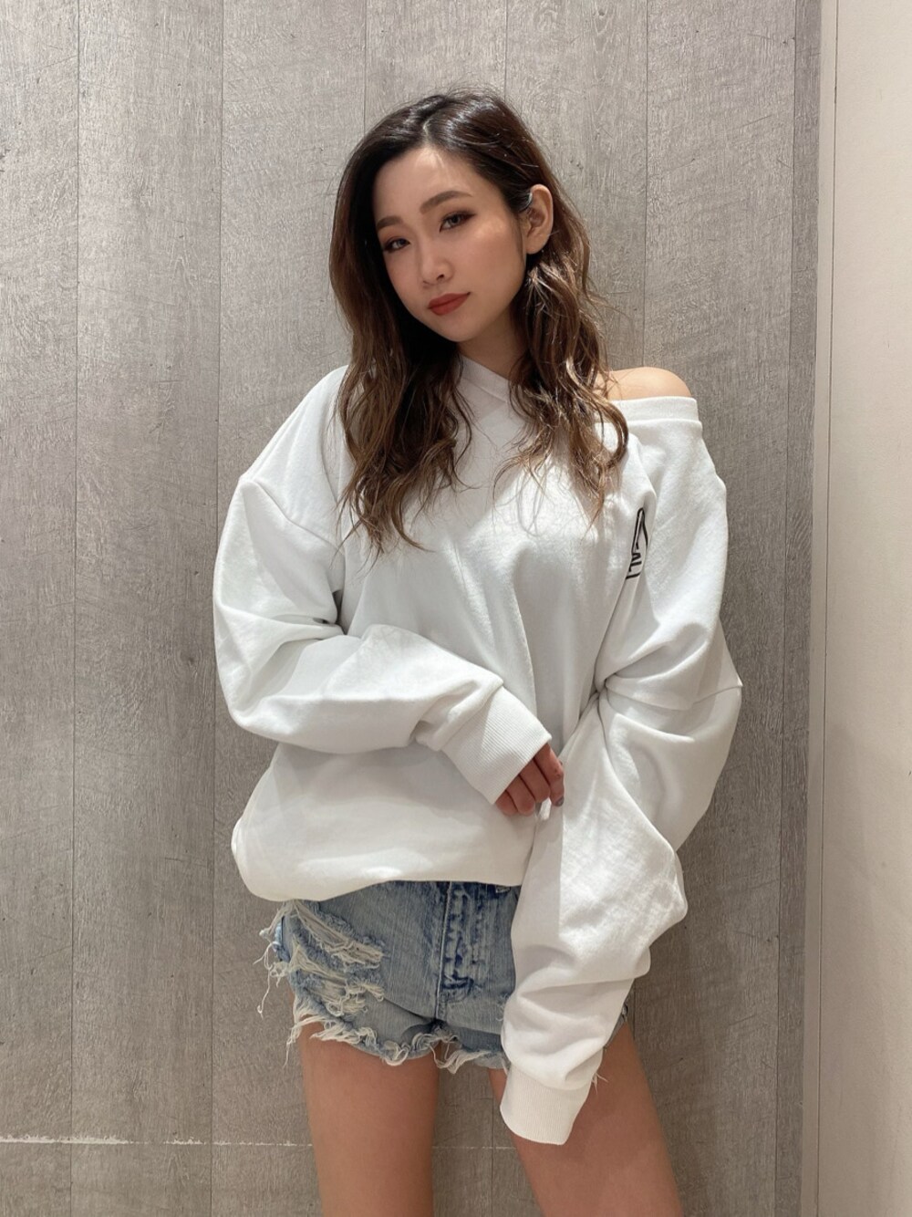 ホワイト系のスウェット、ブルー系のデニムパンツを着用したレディースの冬コーディネートの1枚目の写真