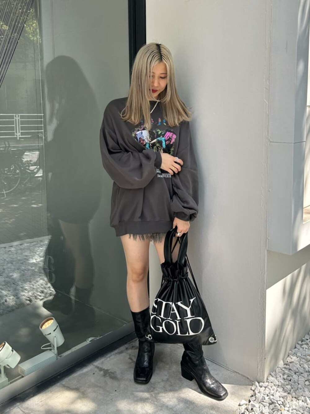 ブラック系のデニムパンツ、ブラック系のバックパック/リュック、ブラック系のブーツを着用したレディースの秋コーディネートの1枚目の写真