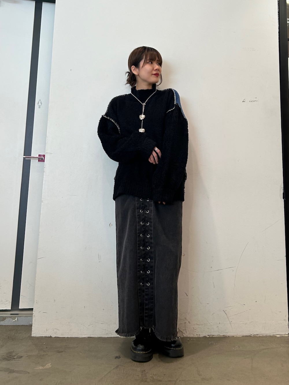 ブラック系のデニムパンツ、ブラック系のブーツ、ブラック系のニット/セーターを着用したレディースの秋コーディネートの1枚目の写真