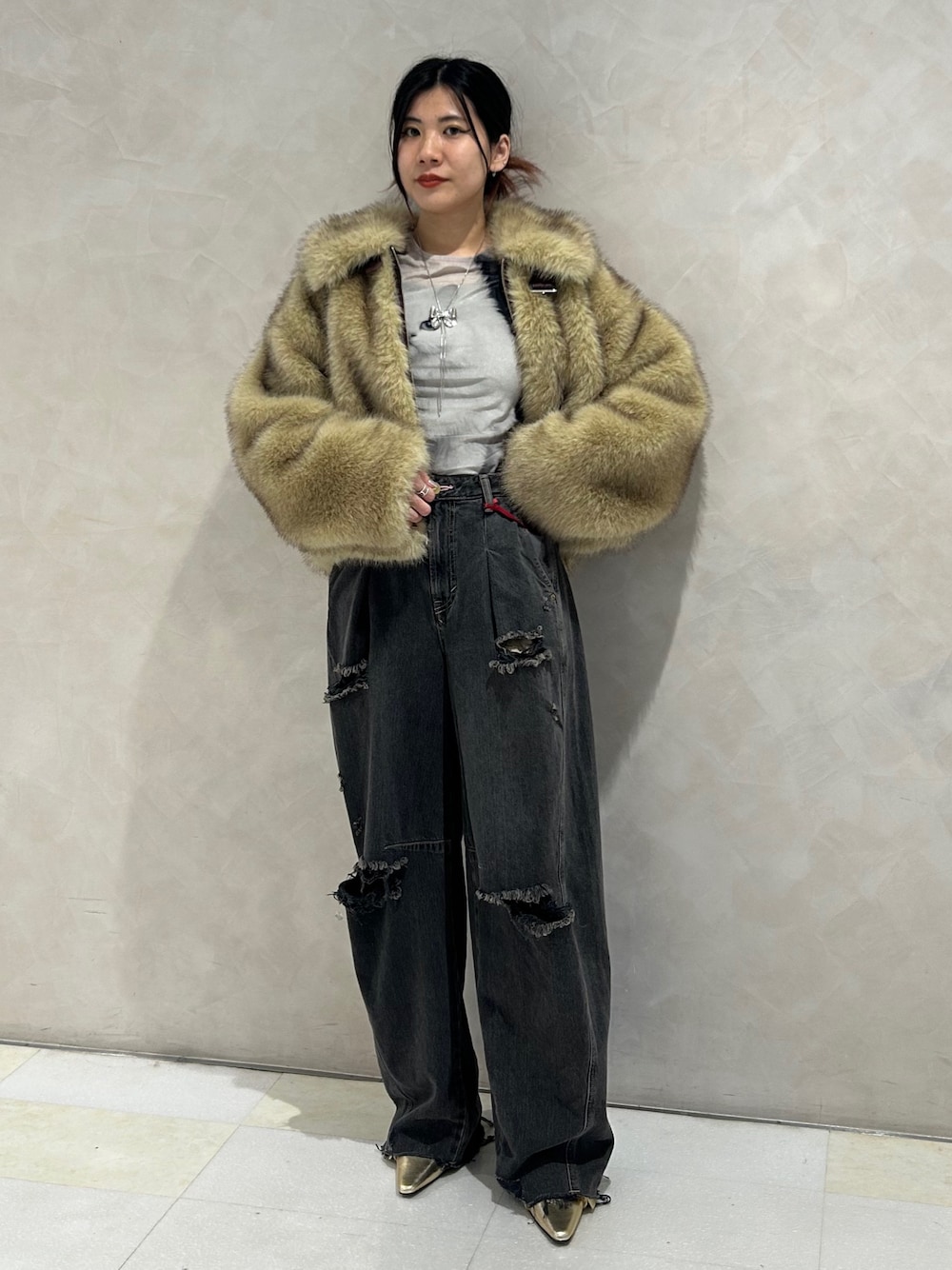 ブラック系のデニムパンツ、ゴールド系のパンプス、ブラック系のTシャツ/カットソーを着用したレディースの秋コーディネートの1枚目の写真