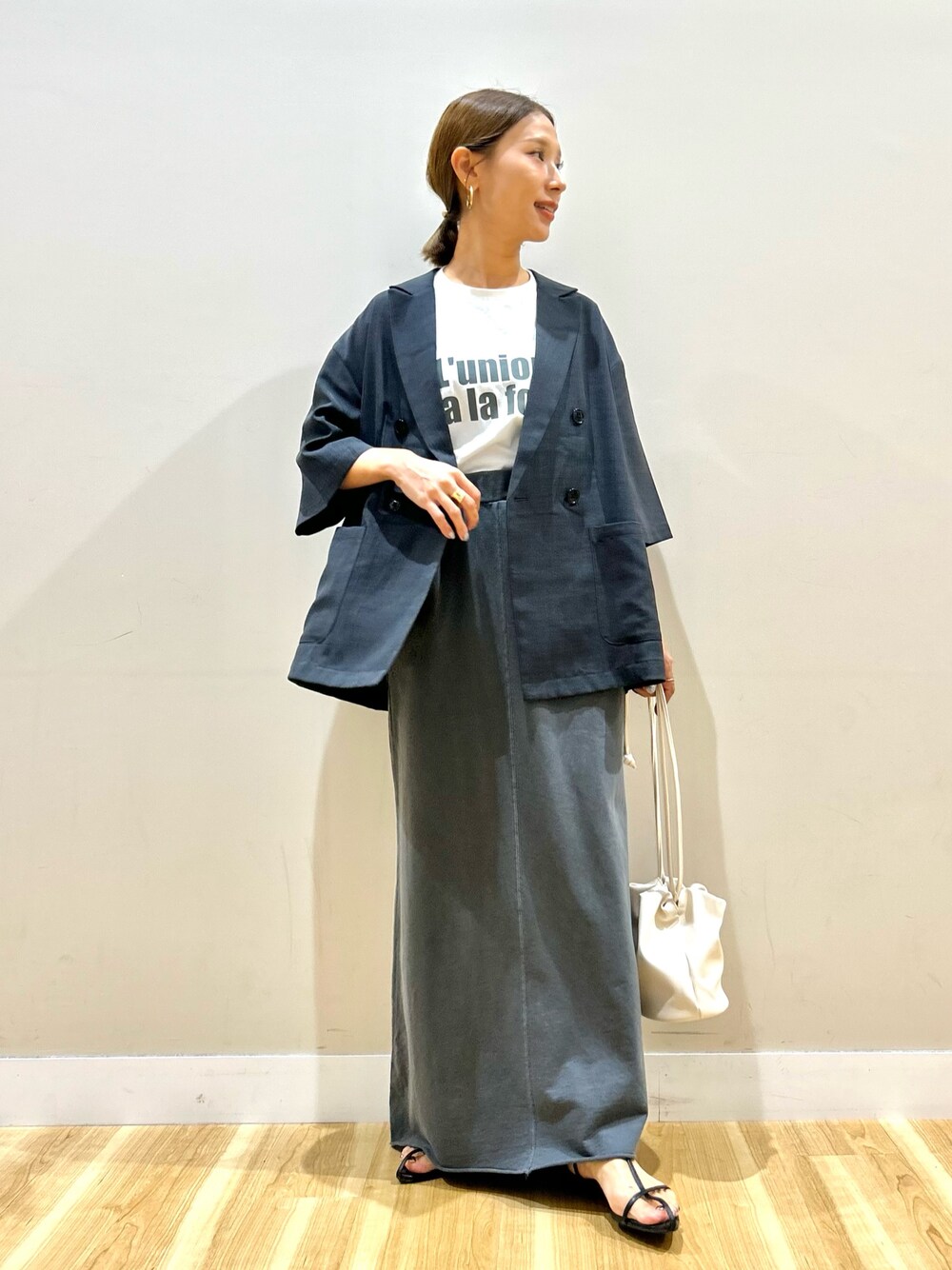 グレー系のその他アウター、ホワイト系のTシャツ/カットソー、ブラック系のスカートを着用したレディースの秋コーディネートの1枚目の写真