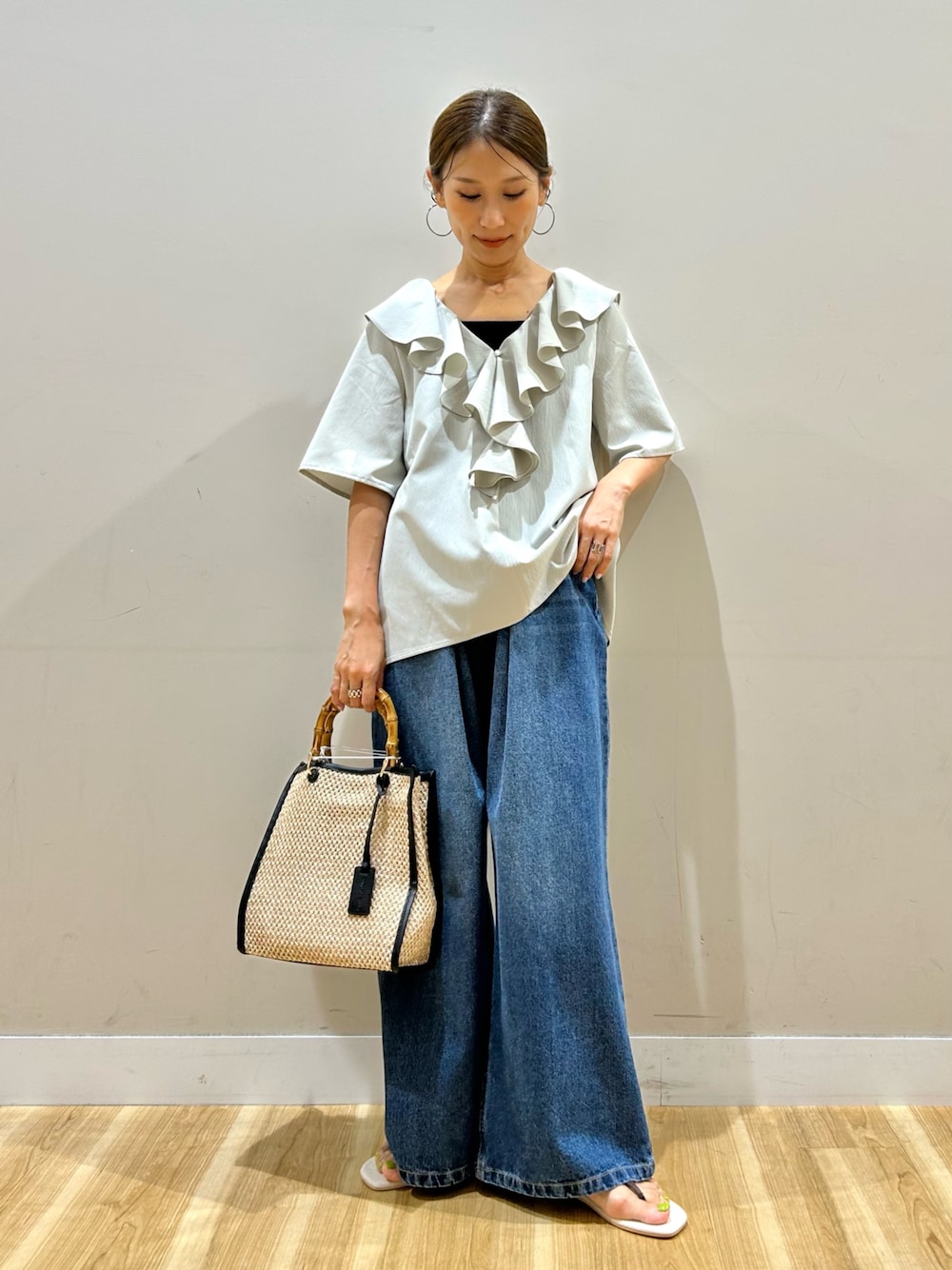 グレー系のシャツ/ブラウス、ブルー系のデニムパンツ、ブラック系のショルダーバッグを着用したレディースの夏コーディネートの1枚目の写真