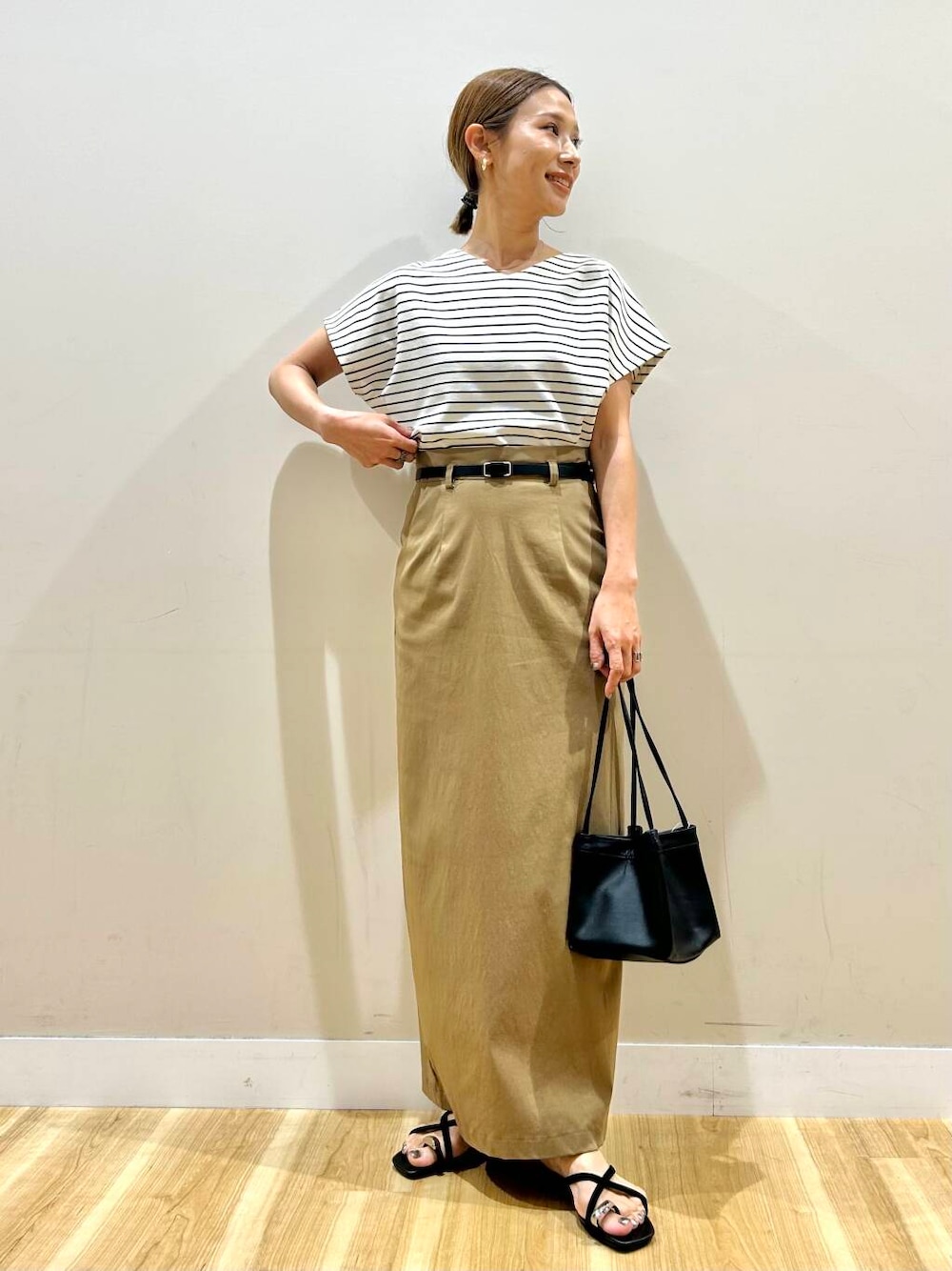 ホワイト系のTシャツ/カットソー、ブラック系のハンドバッグ、イエロー系のスカートを着用したレディースの夏コーディネートの1枚目の写真