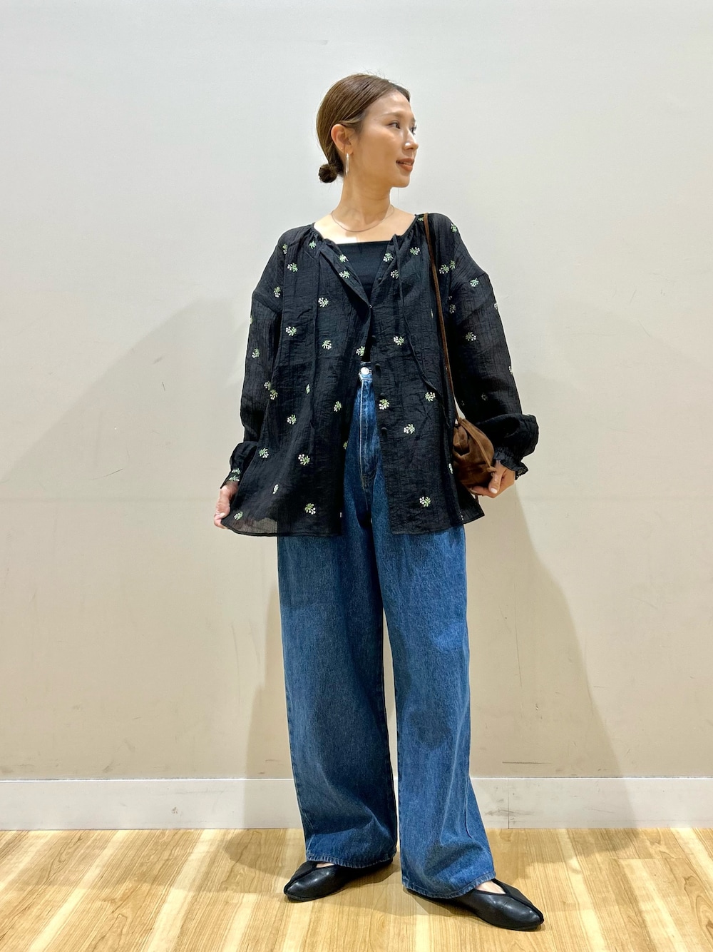ブラック系のシャツ/ブラウス、ブルー系のデニムパンツ、ブラウン系のショルダーバッグを着用したレディースの春コーディネートの1枚目の写真