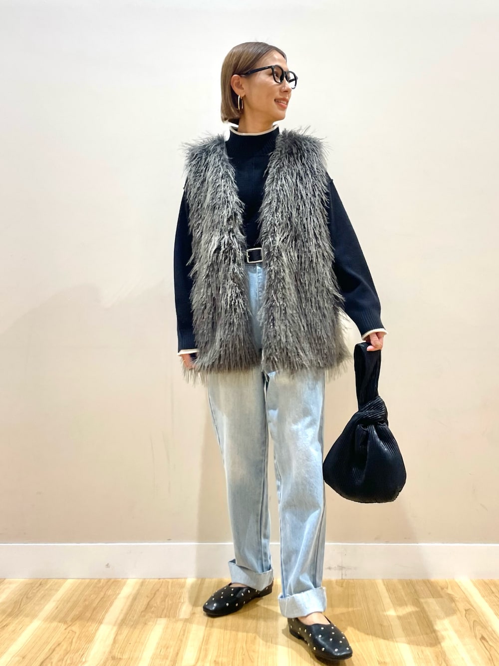 グレー系のその他アウター、ブラック系のニット/セーター、ブルー系のデニムパンツを着用したレディースの秋コーディネートの1枚目の写真