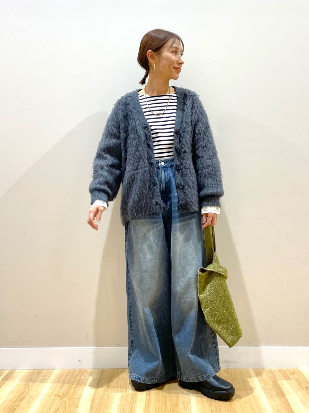 グレー系のカーディガン/ボレロ、ホワイト系のTシャツ/カットソー、ブルー系のデニムパンツを着用したレディースの冬コーディネートの1枚目の写真