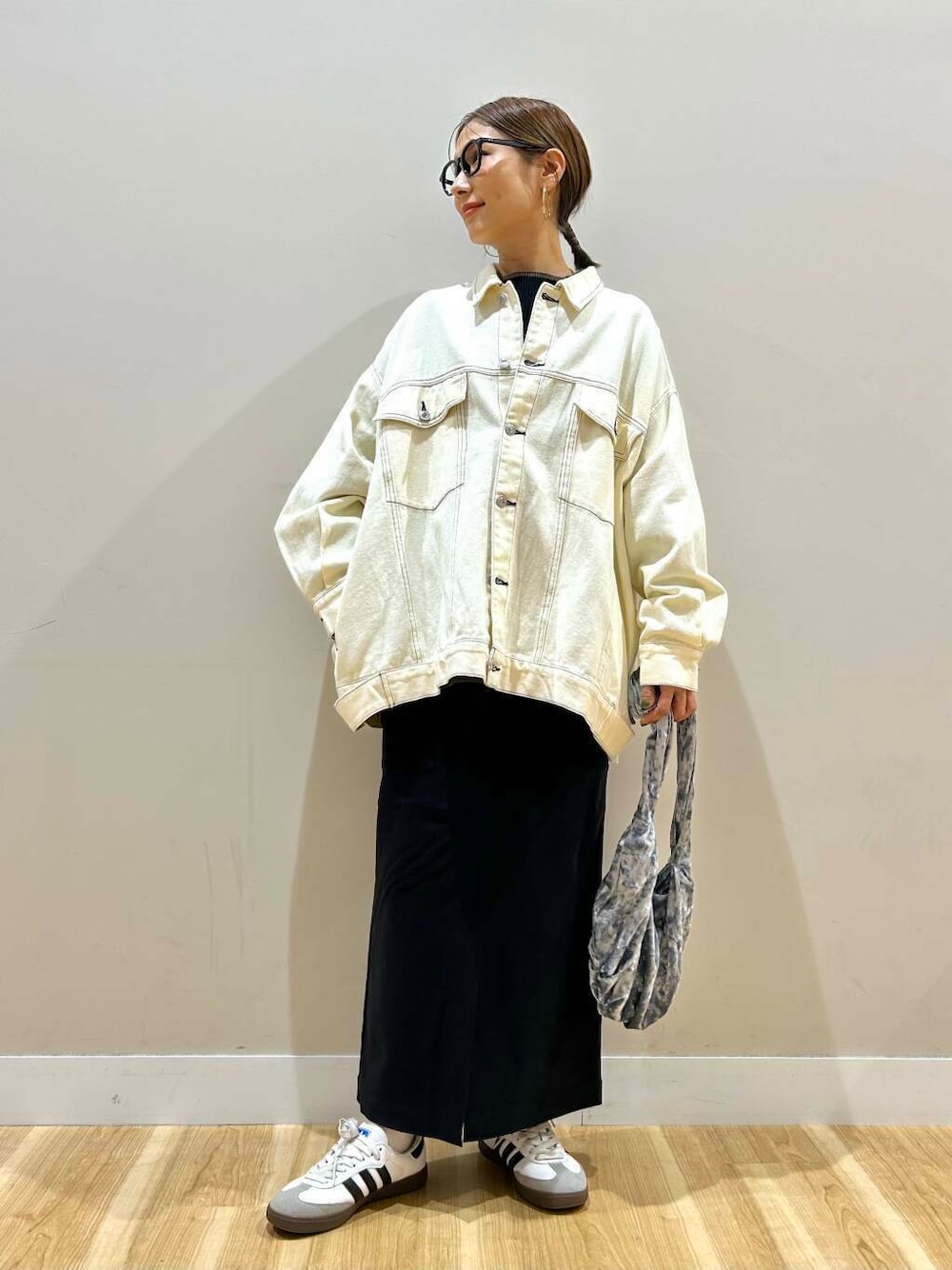 グレー系のハンドバッグ、ブラック系のニット/セーター、ブラック系のスカートを着用したレディースの冬コーディネートの1枚目の写真